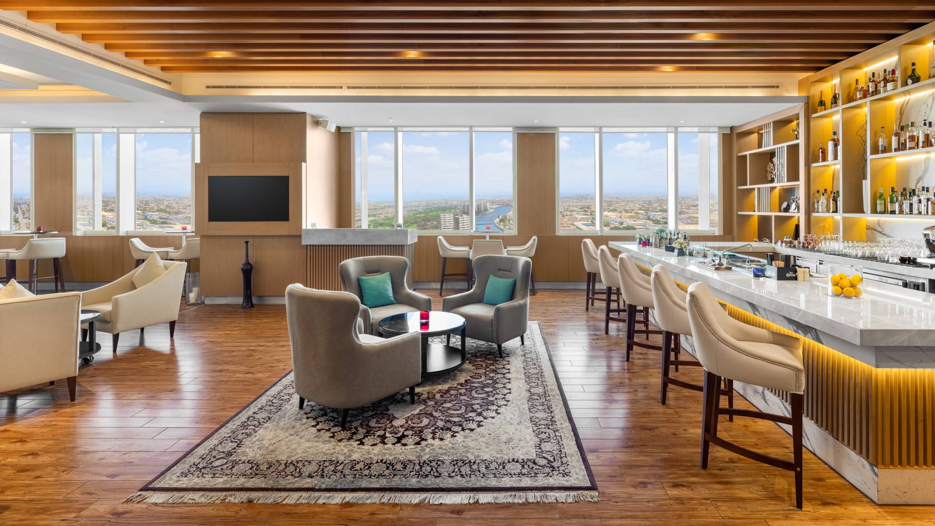 Lounge with bar seating and soft seating areas with outside view.