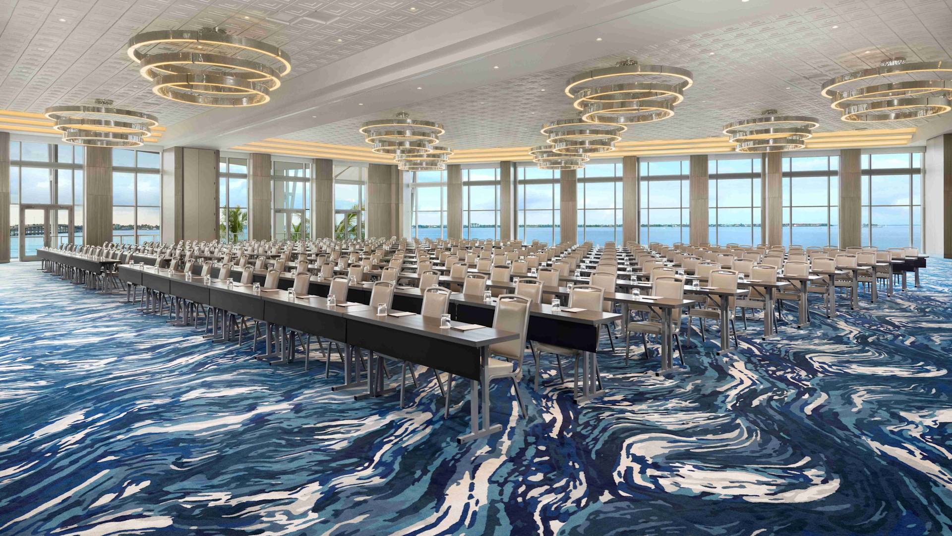 水に面した2面の窓を備えた宴会場「グレート・エグレット」。テーブルと椅子を備えたクラスルームスタイルの客室