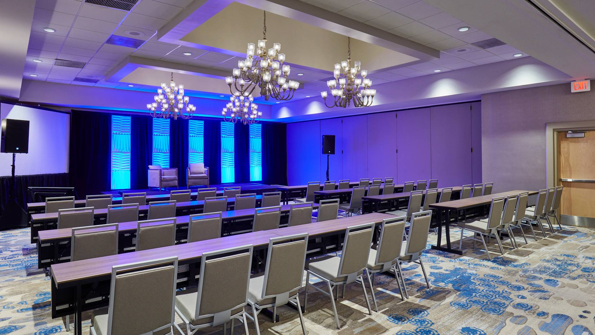 Salón de fiestas con montaje tipo aula y pantallas para proyector