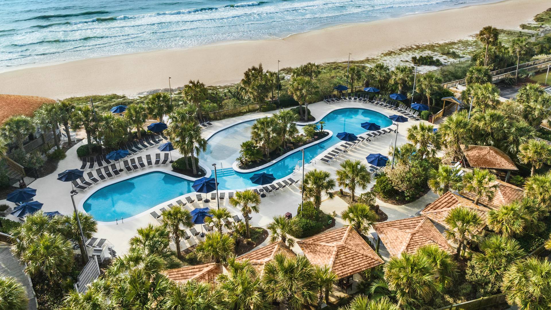 Aerial view of stunning hotel pool, beach, and ocean.