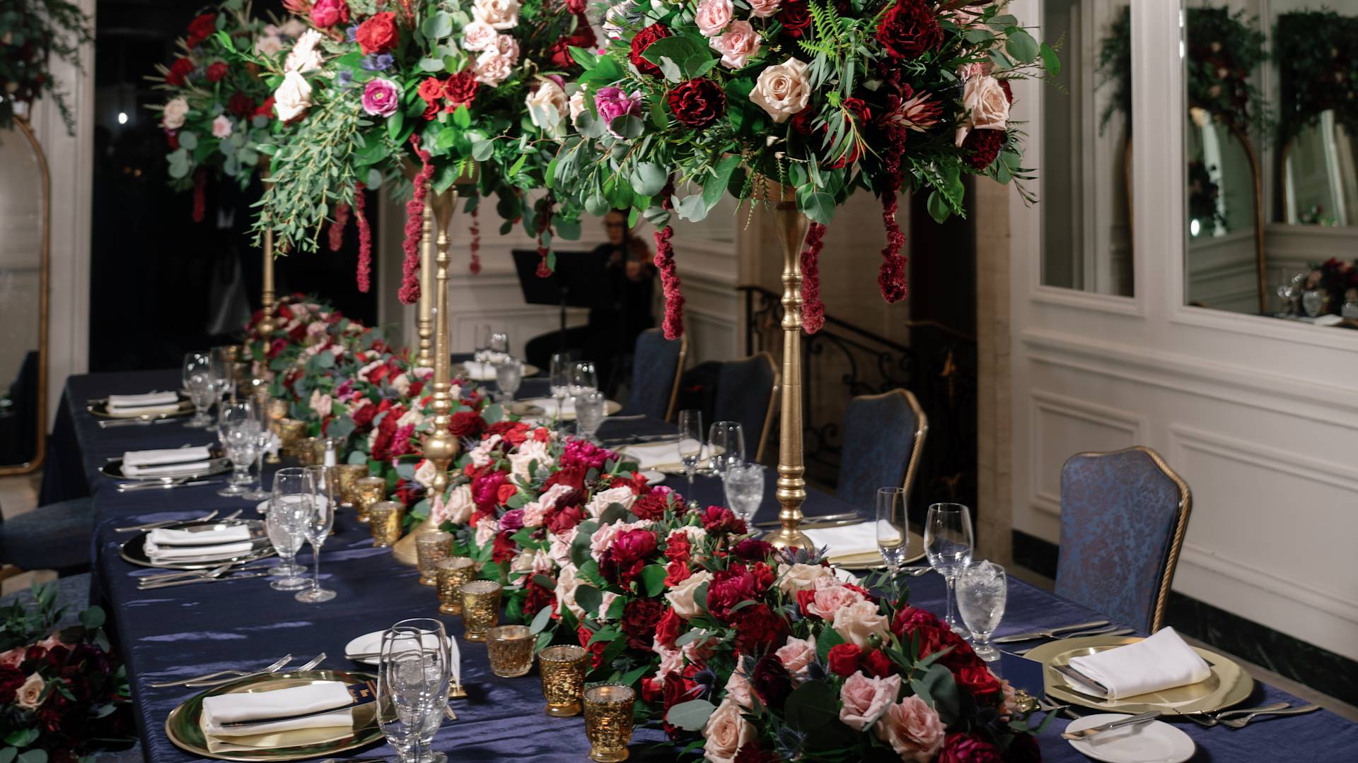 Flower Arrangements with Red, White and Pink Roses on a Table to celebrate a Wedding