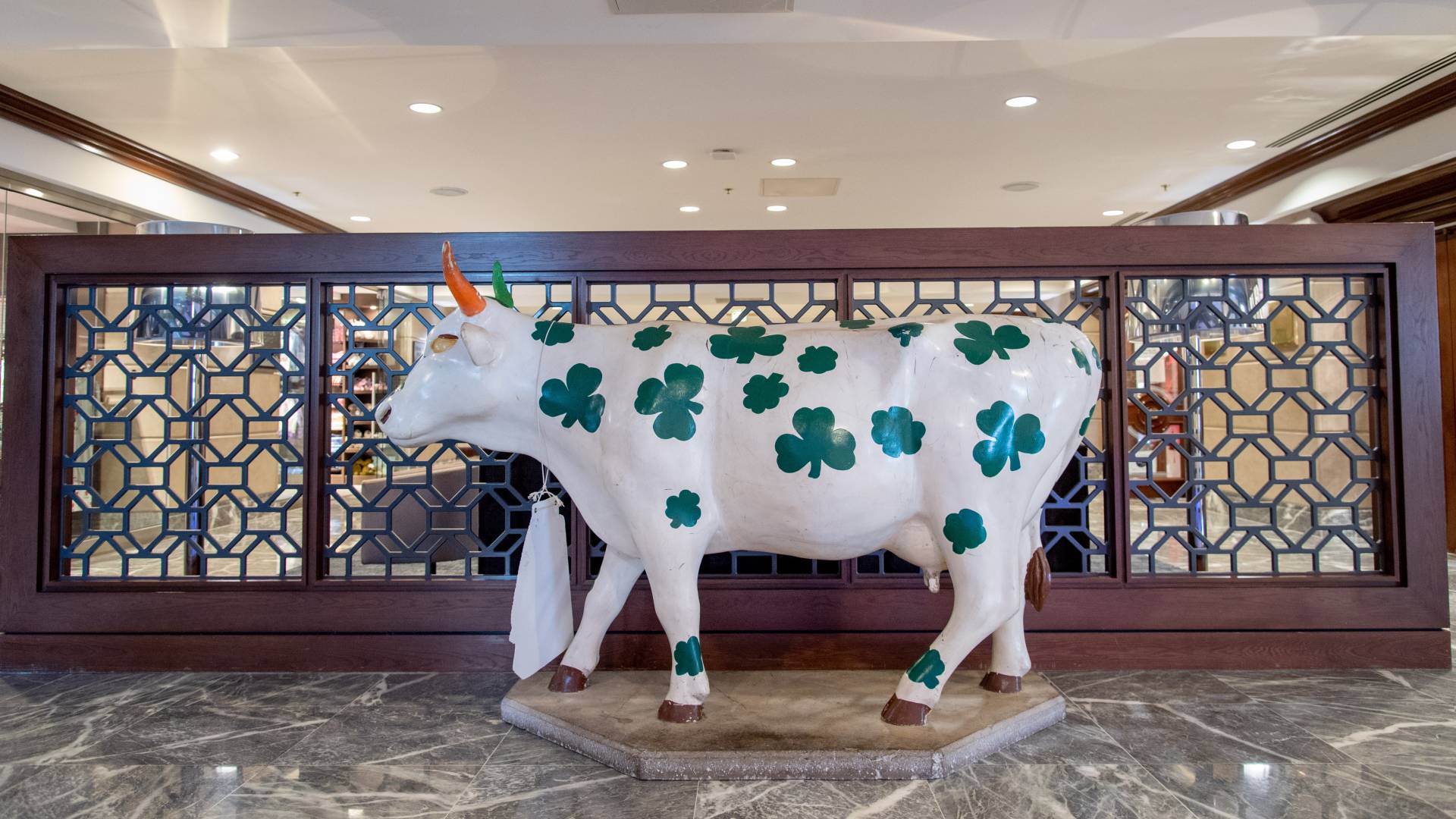 Decorative Statue of a White Cow with Prints of Green Clover