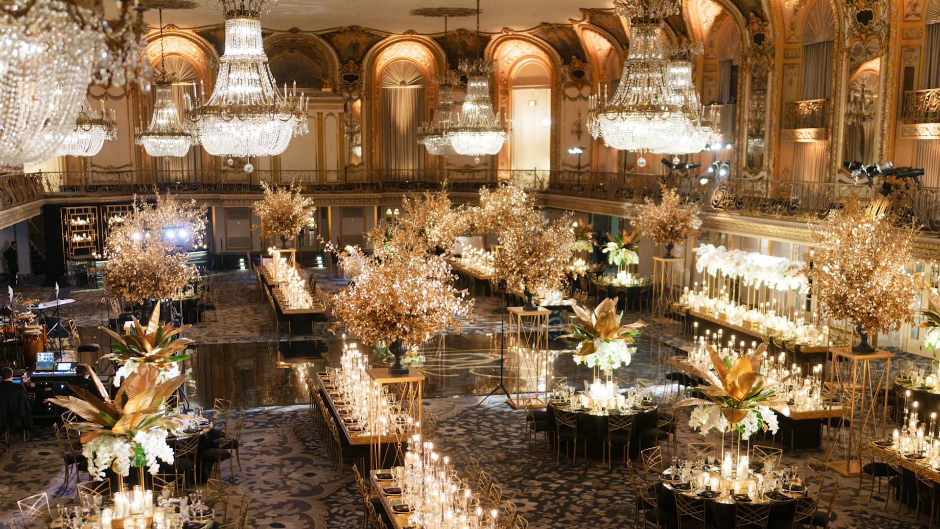 Balzaal ingericht met bloemen en kaarsen op grote tafels om een bruiloft te vieren
