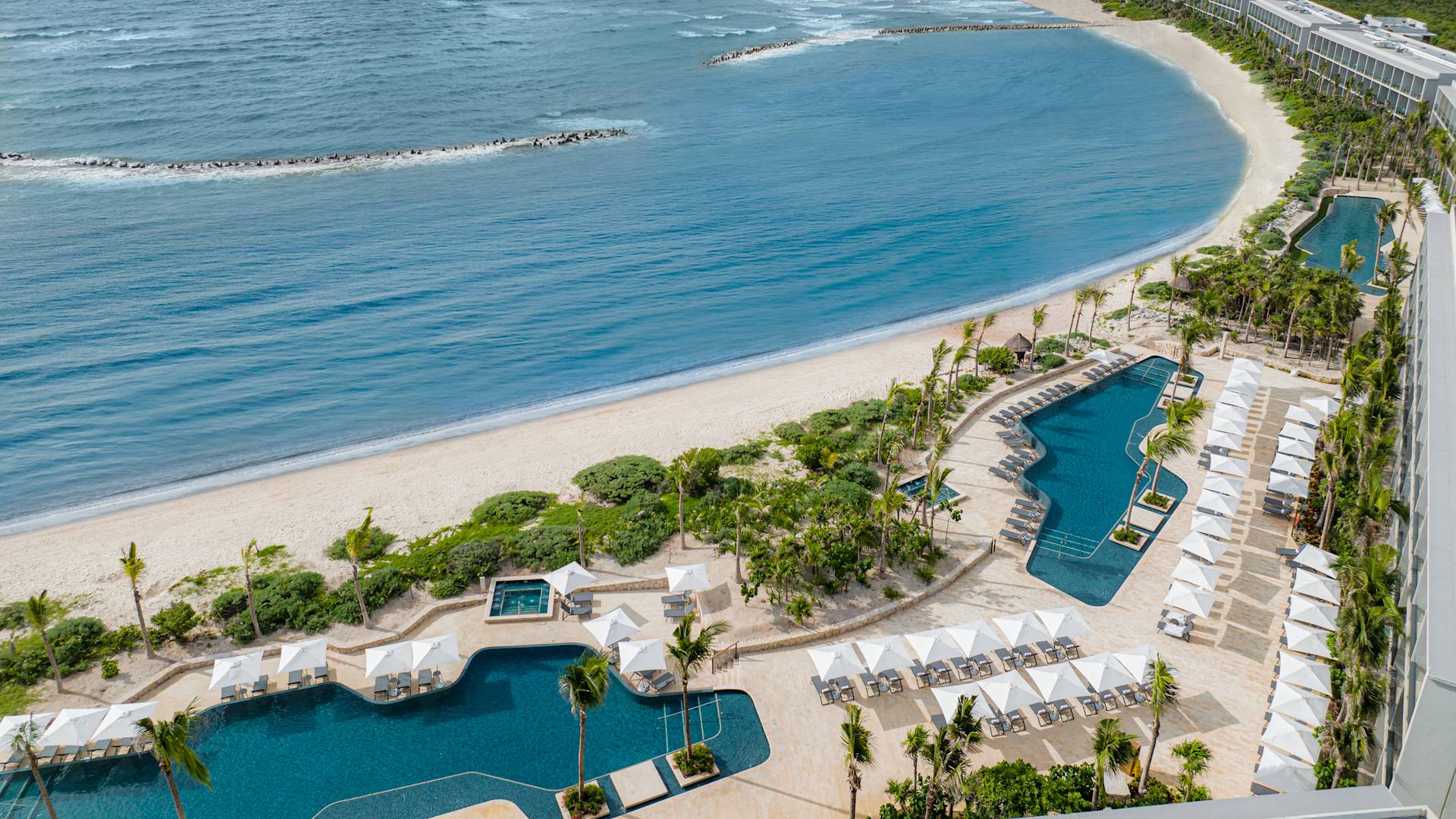 Aerial View of Hilton Tulum Hotel Exterior with Three Large Pool Areas Near the Beach