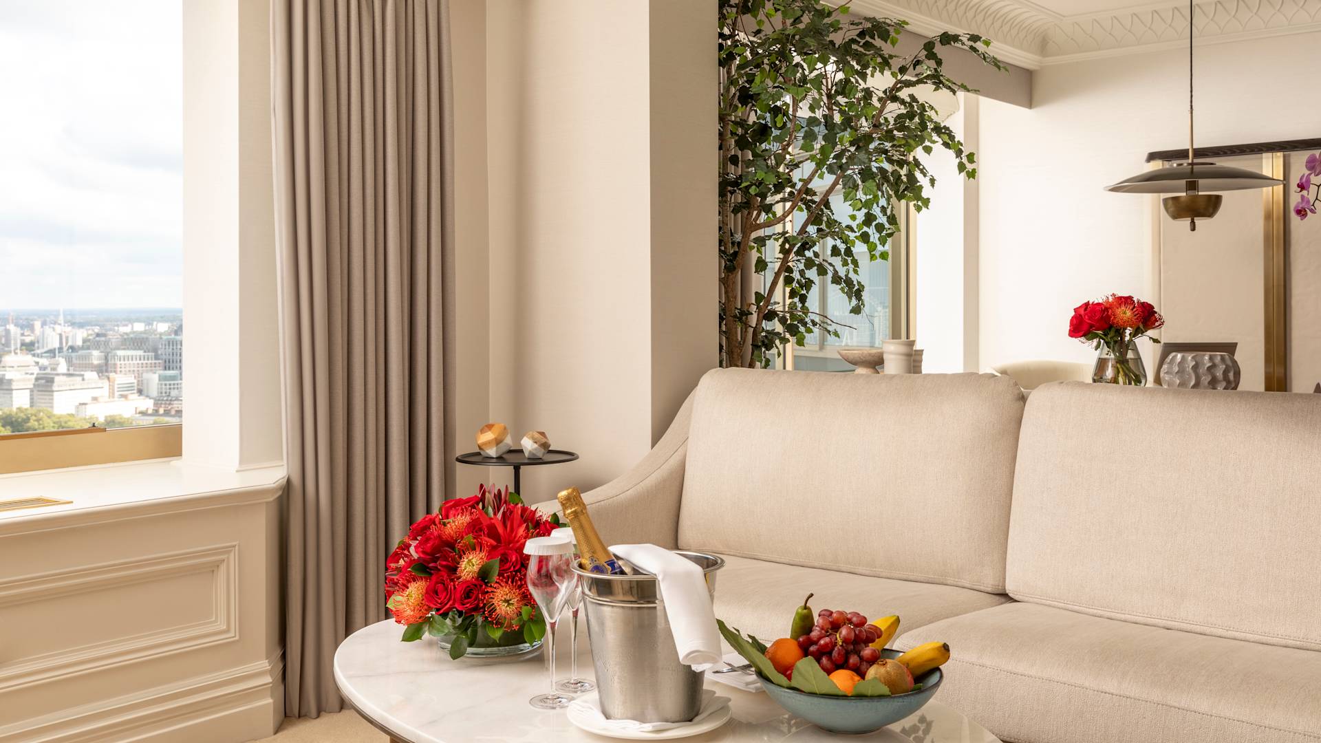 Champán, flores y frutas frescas en la sala de estar de la suite