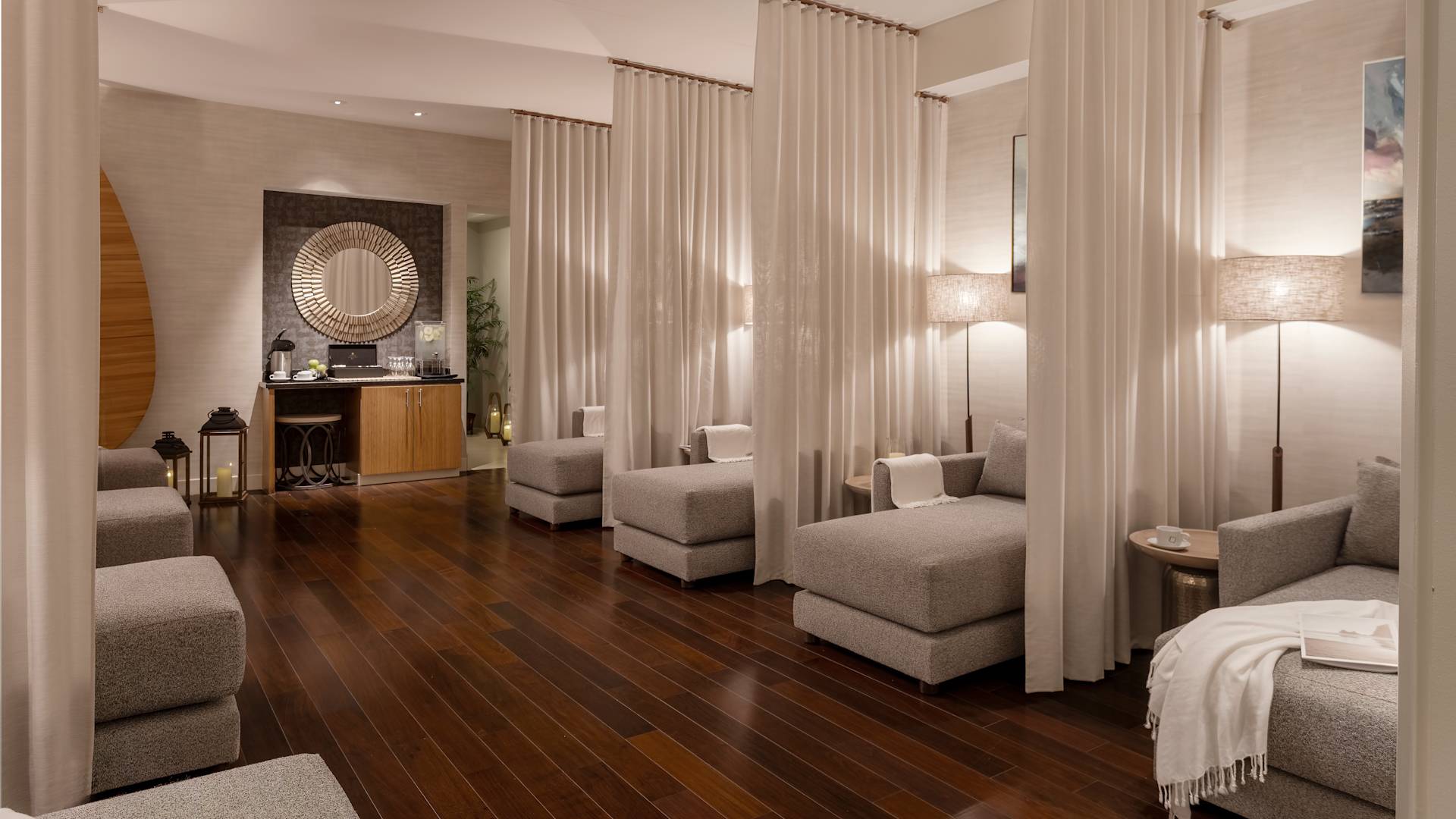 spa lounge chairs separated by curtains, table with water and snacks