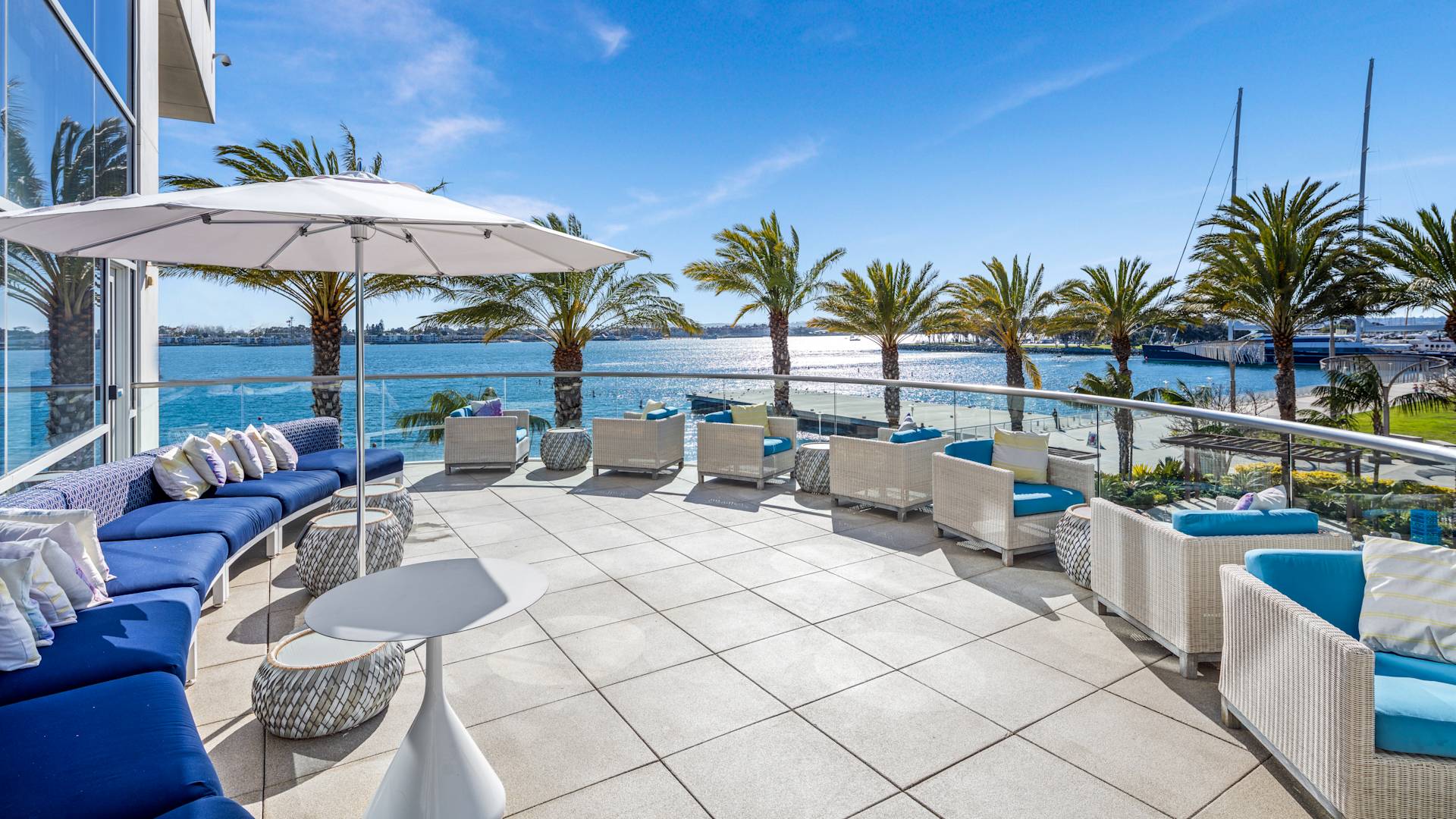 Odysea restoran terası, lounge sandalyeleri, şemsiye, palmiye ağaçları, okyanus manzarası