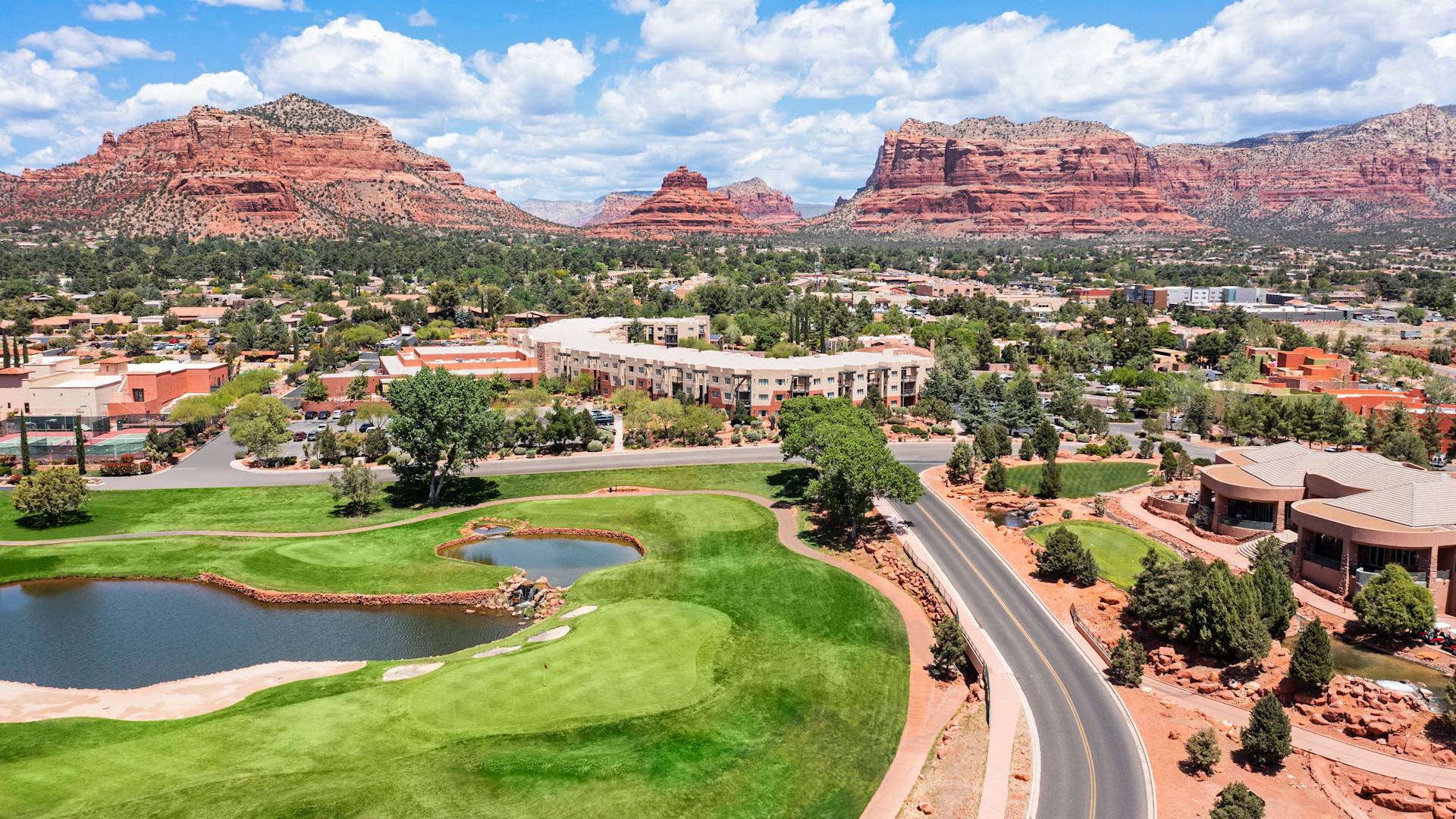 Panoramic View of Hotel Exterior Surrounded by Mountains and a Pond