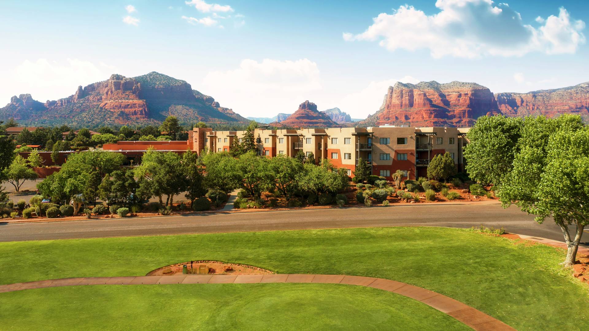 Hotel Exterior with Red Mountains in Background and Golf Course in Front