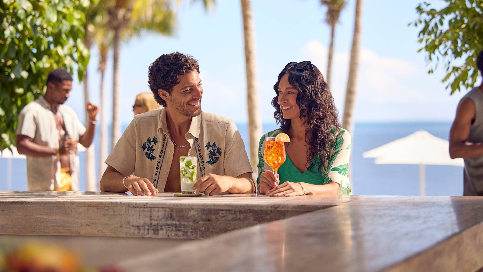 Man and woman enjoying a drink at the beach bar