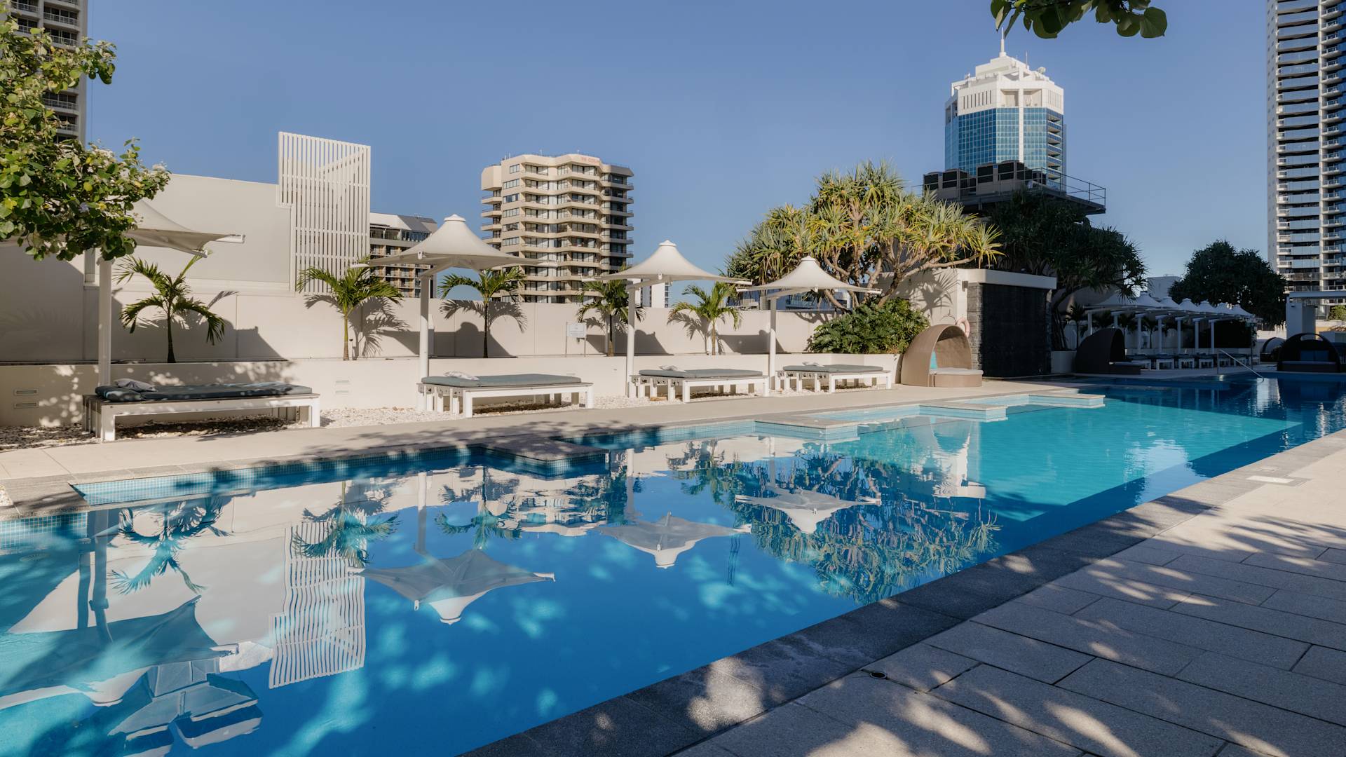 outdoor pool, lounge chairs, umbrellas