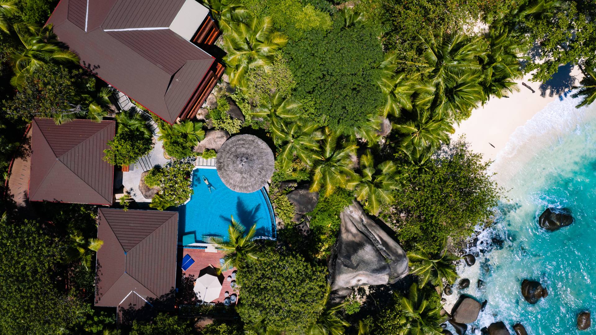 Aerial View of Hotel Exterior with Pool Area by the Beach
