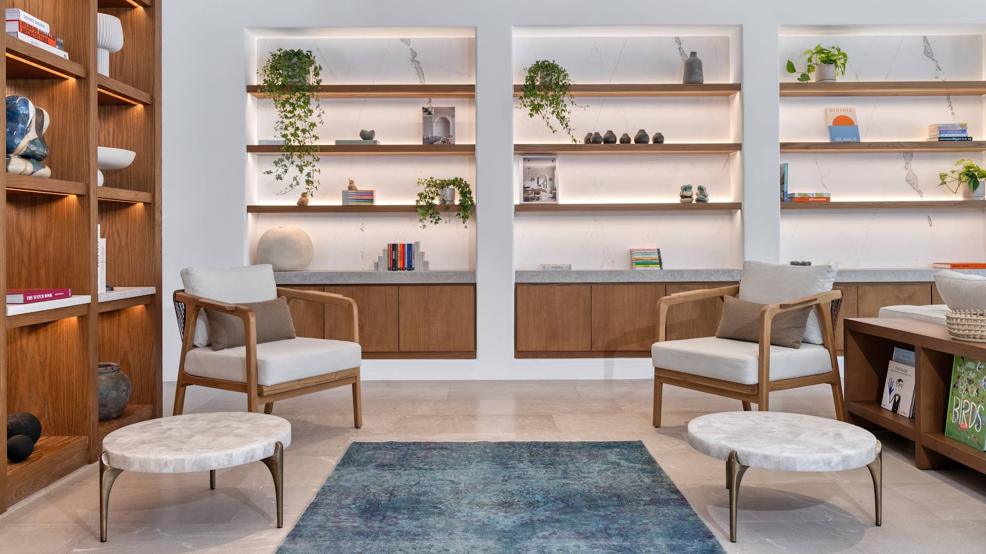 Sitzbereich in der Lobby mit vier Stühlen und Wandregalen. 