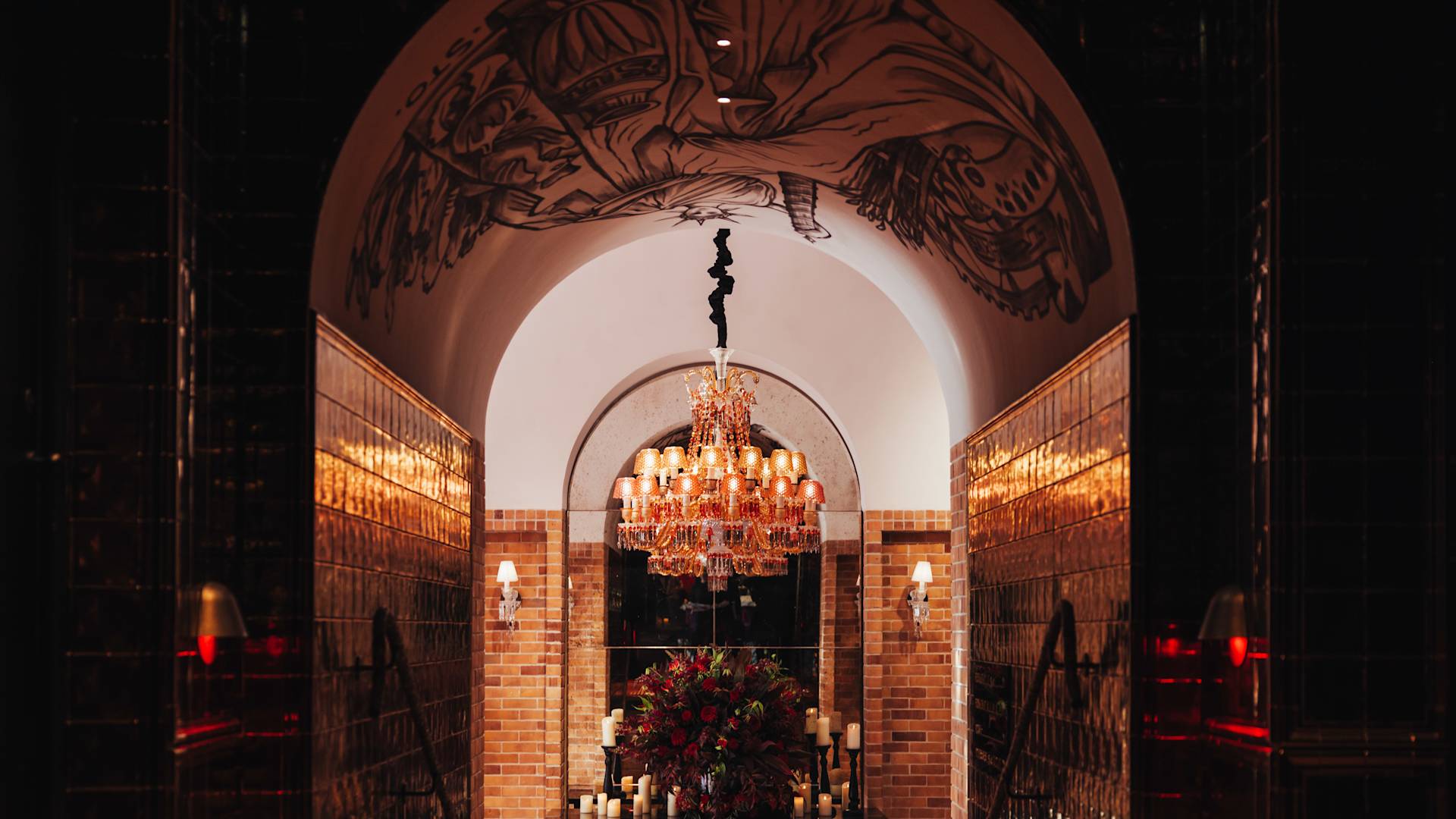 Entrance to hotel reception with flower arrangement and chandelier