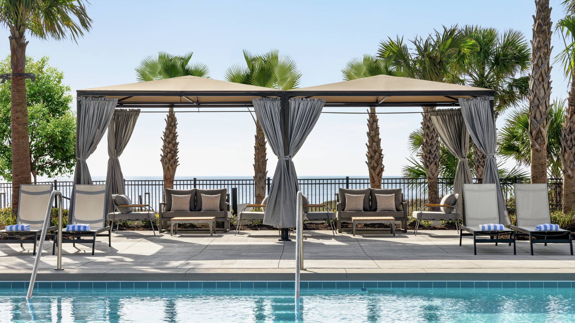 Beautiful outdoor poolside cabanas with view of ocean