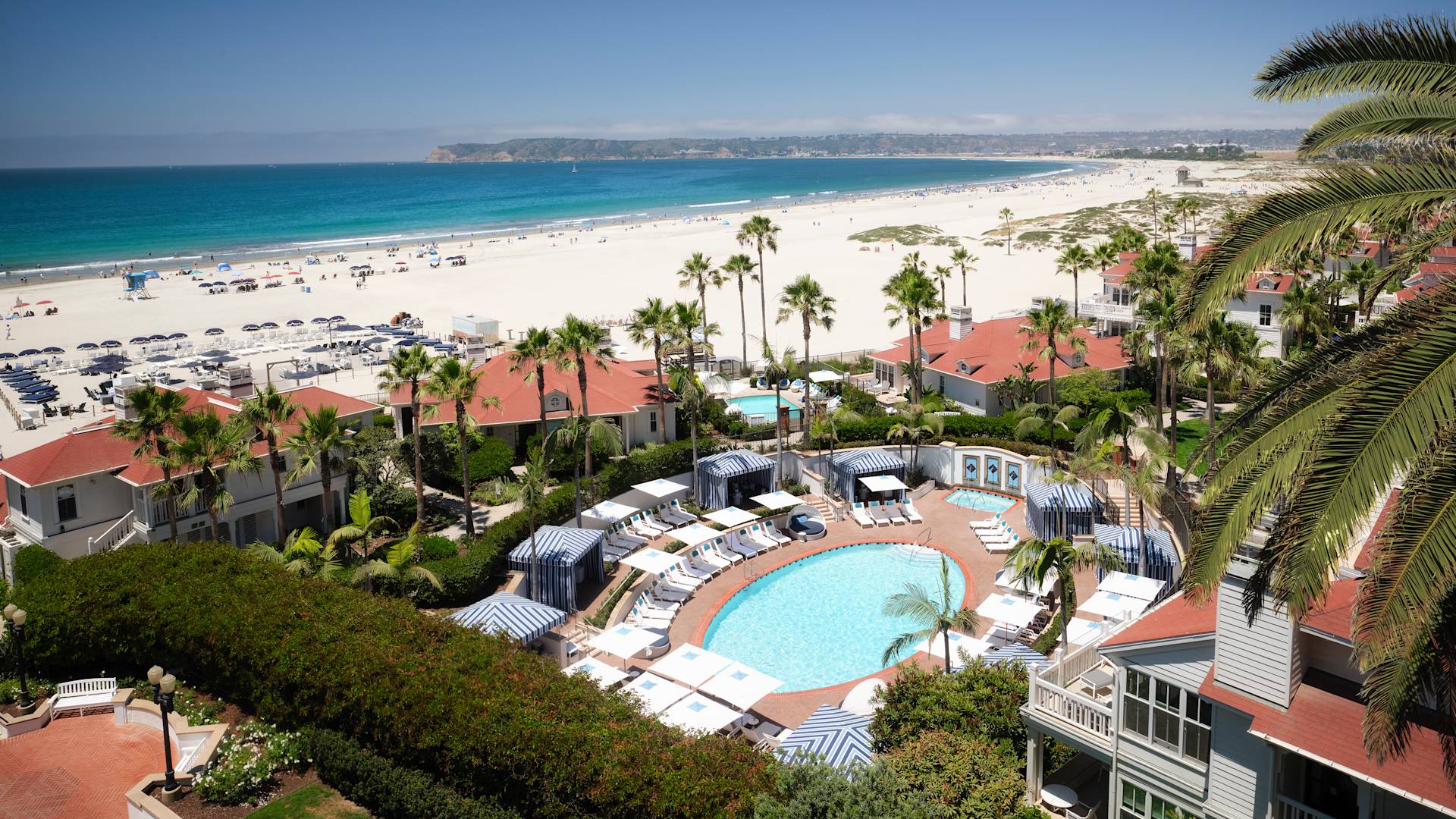 Overhead view of pool with loungers, and beach in background