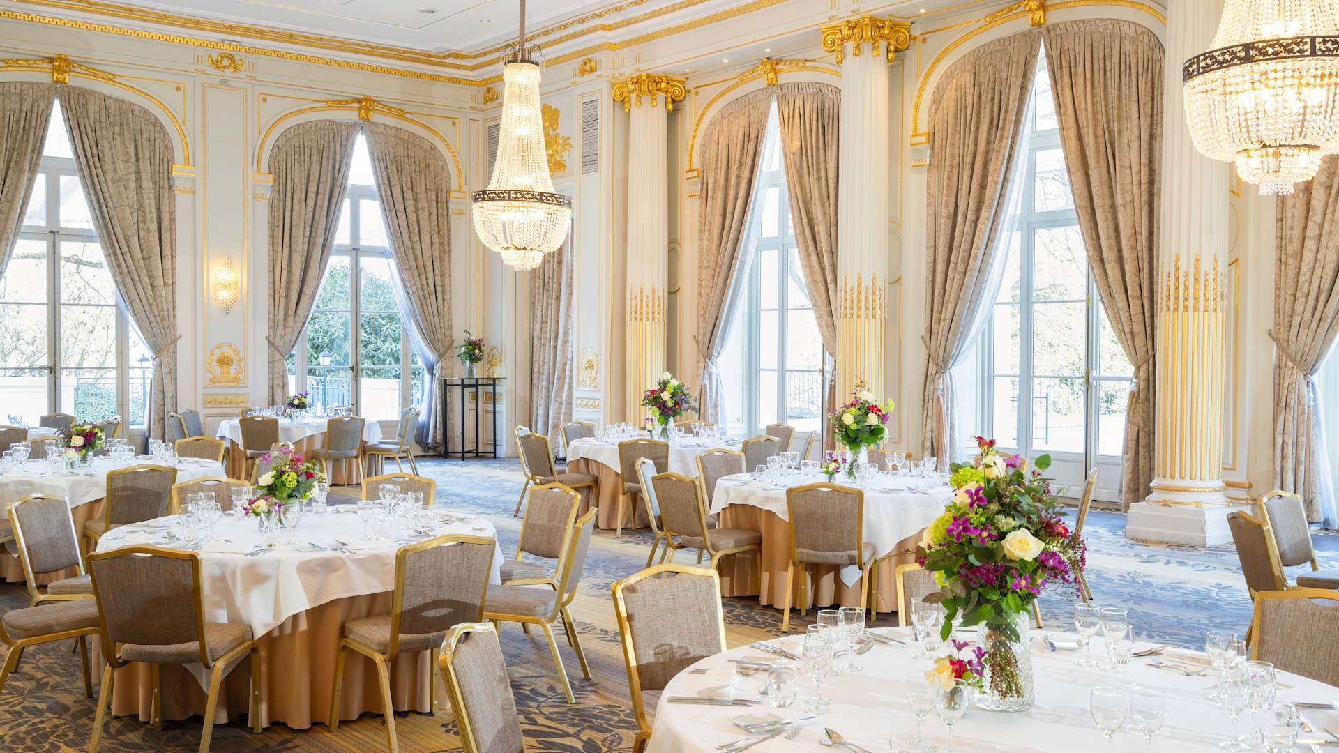 Salle de réception de mariage aménagée avec des compositions florales