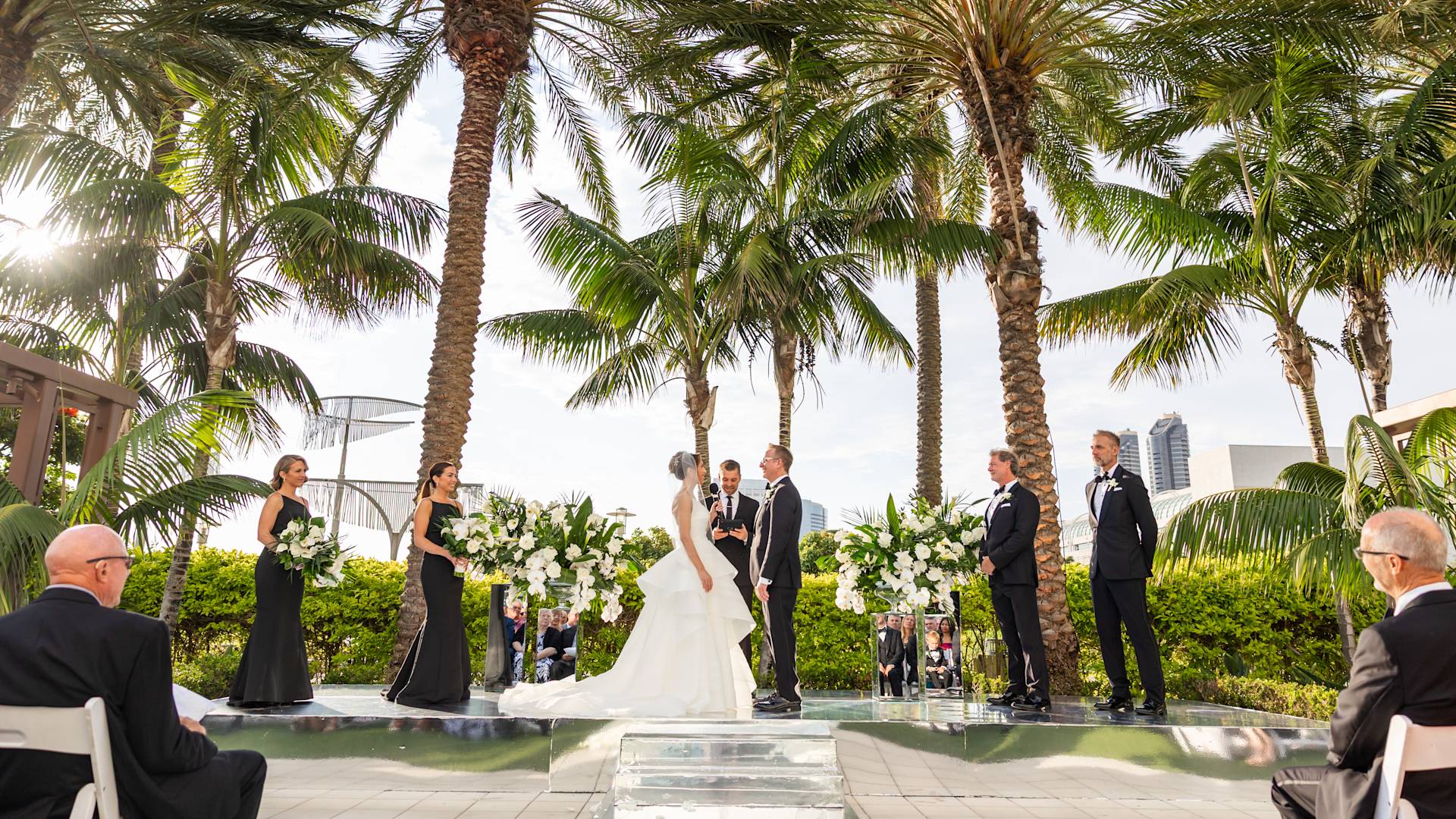 Upacara pernikahan luar ruangan di bawah pohon palem