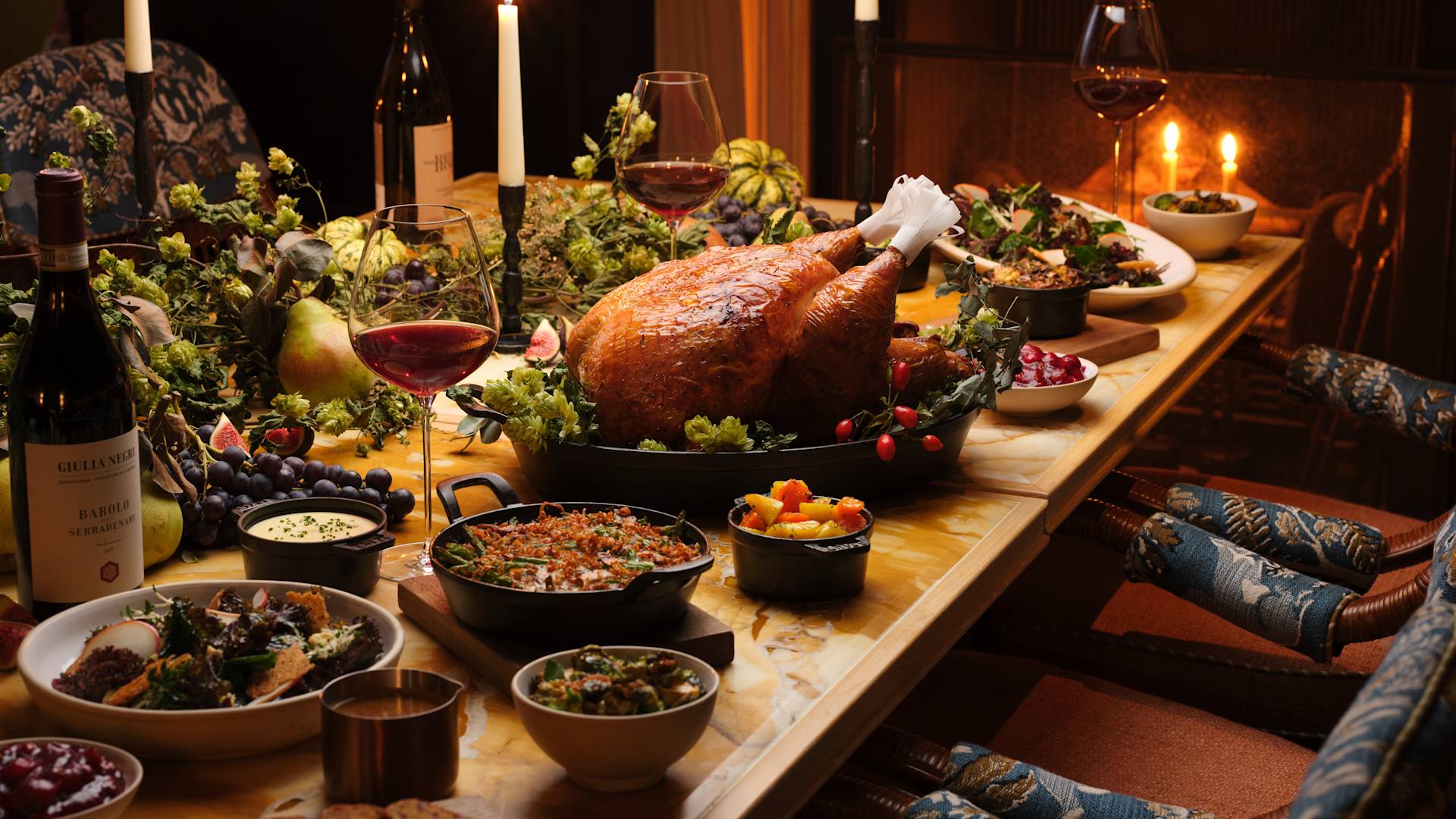 Table with Turkey, salads and sides decorated festively for Thanksgiving