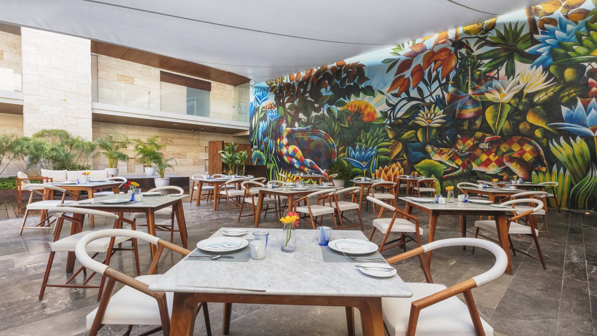 Coin détente avec tables et chaises avec une grande fresque murale au mur