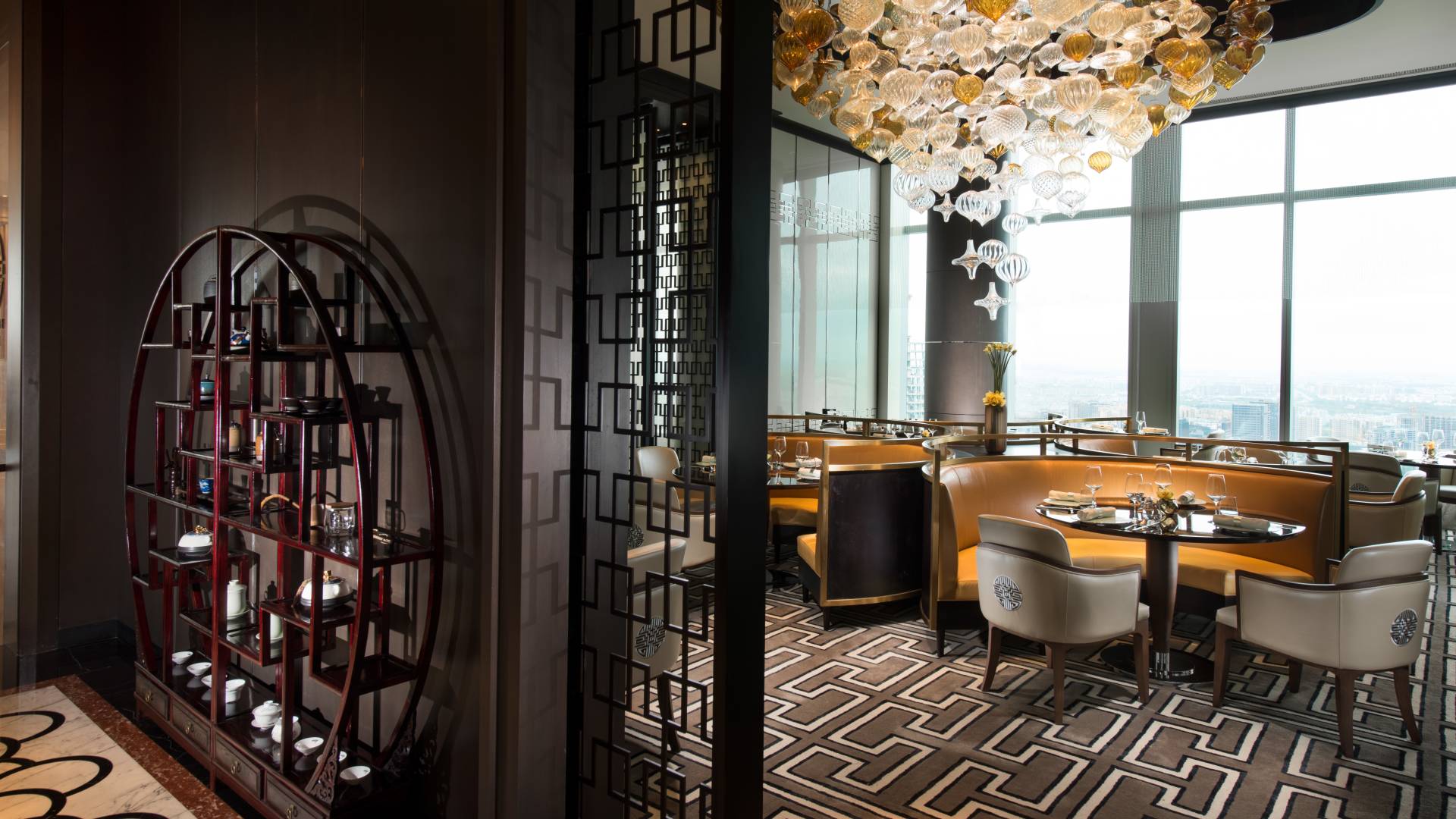 Infinite Luck Chinese restaurant with dining booths, chairs, and floor-to-ceiling windows with outdoor view