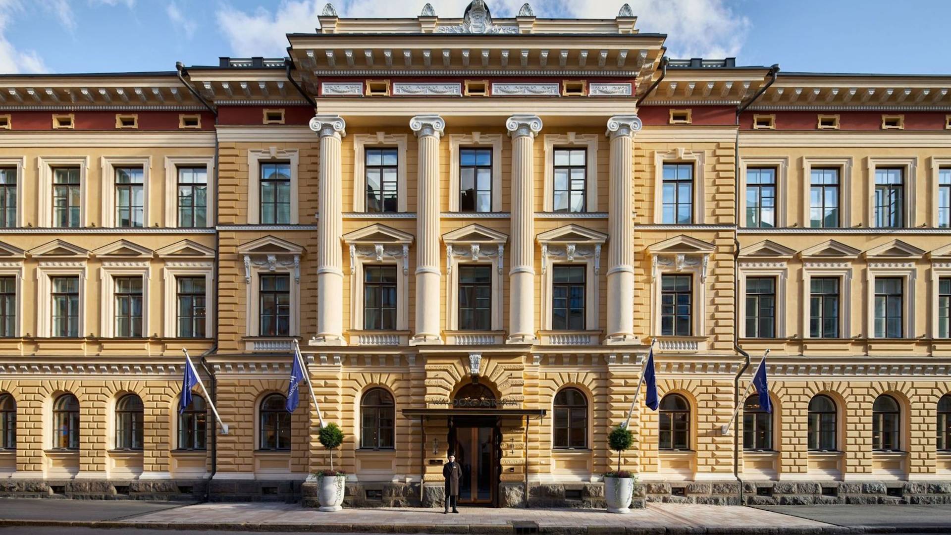 Eksterior Hotel dengan bendera terbang dan penjaga pintu berdiri di luar