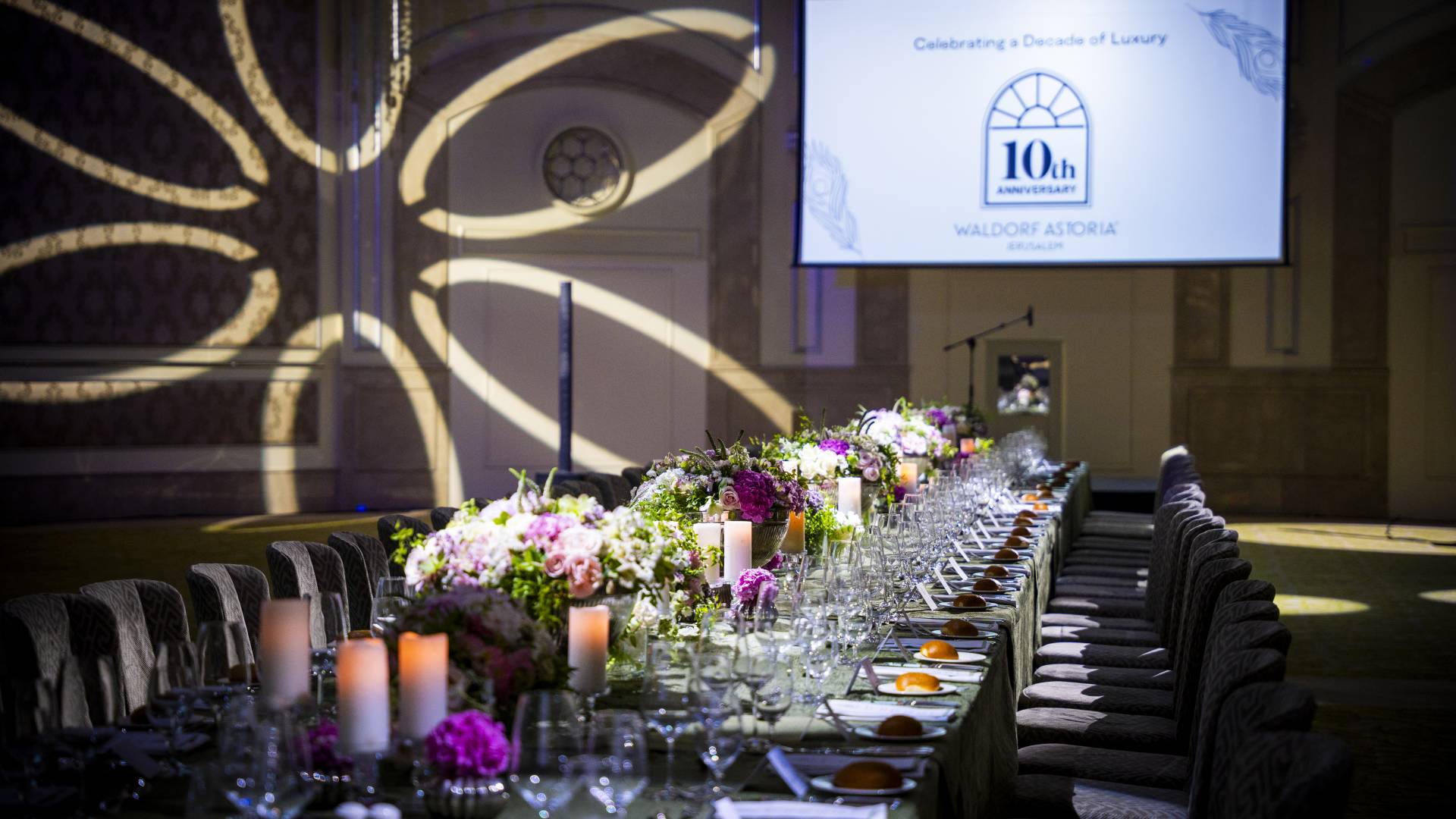 Large Table Setup with Flowers and Candles to Celebrate the 10th Anniversary in a Ballroom at the Waldorf Astoria Jerusalem