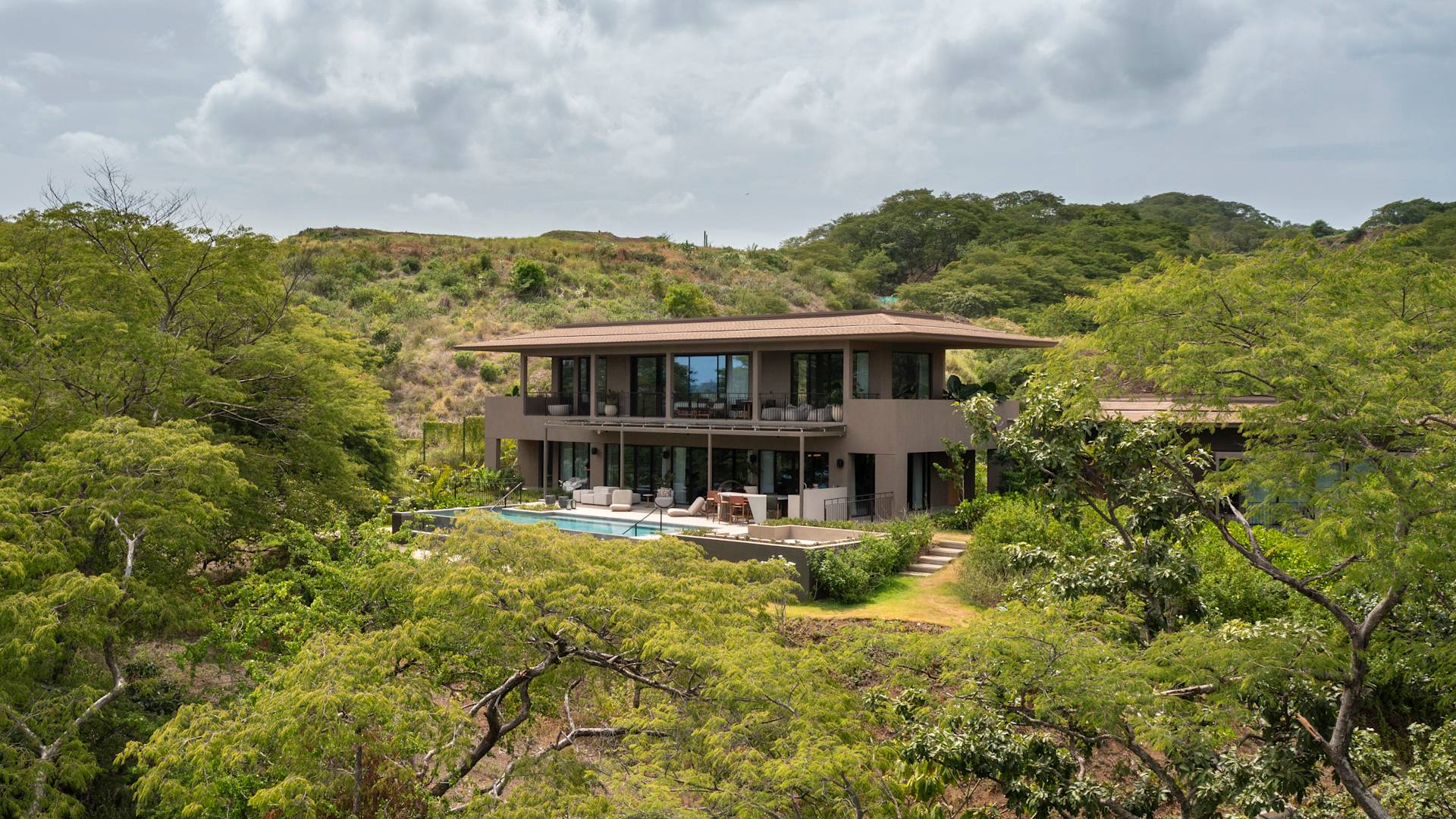 outside view of the presidential suite with private outdoor pool surrounded by trees and hills