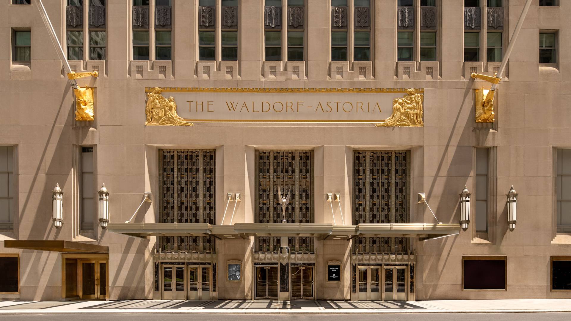Hotel exterior with entrance and signage reading 'The Waldorf Astoria'