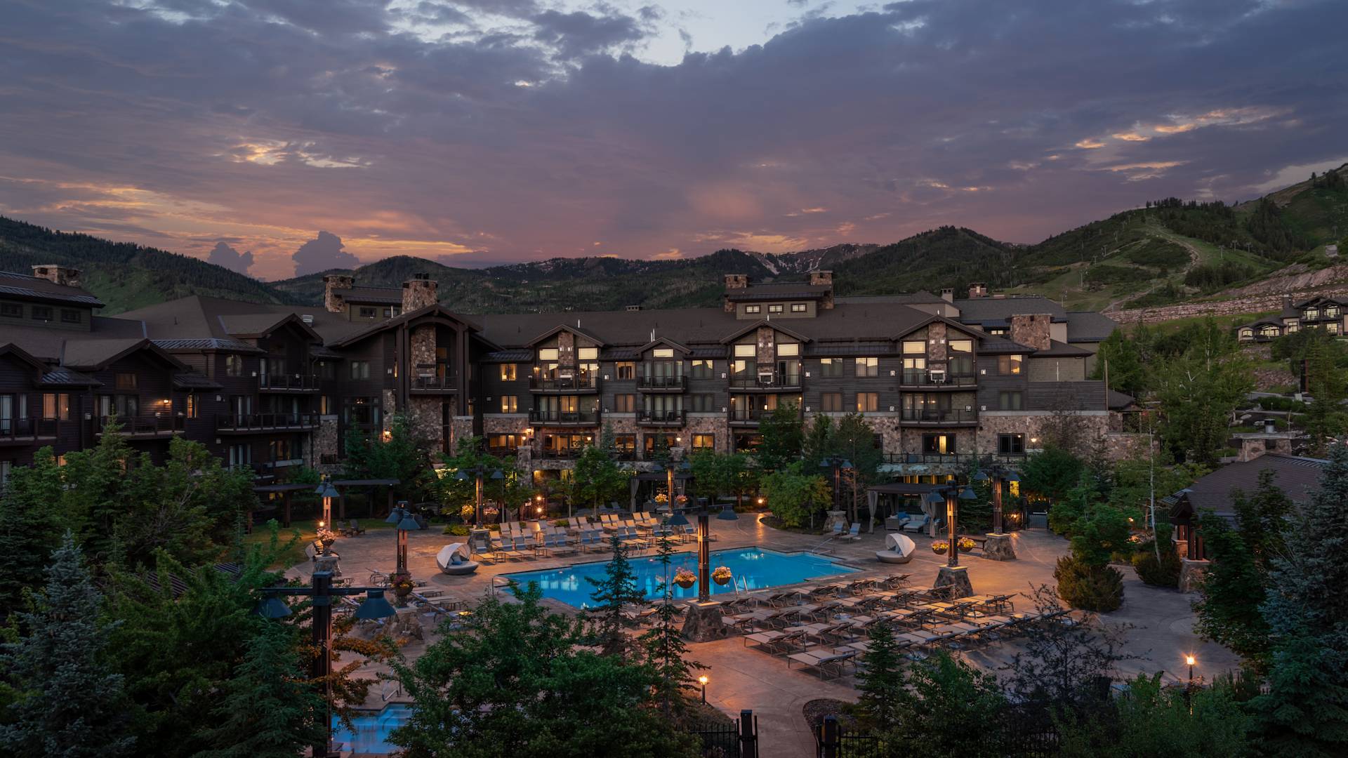 view of hotel exterior and pool at dusk