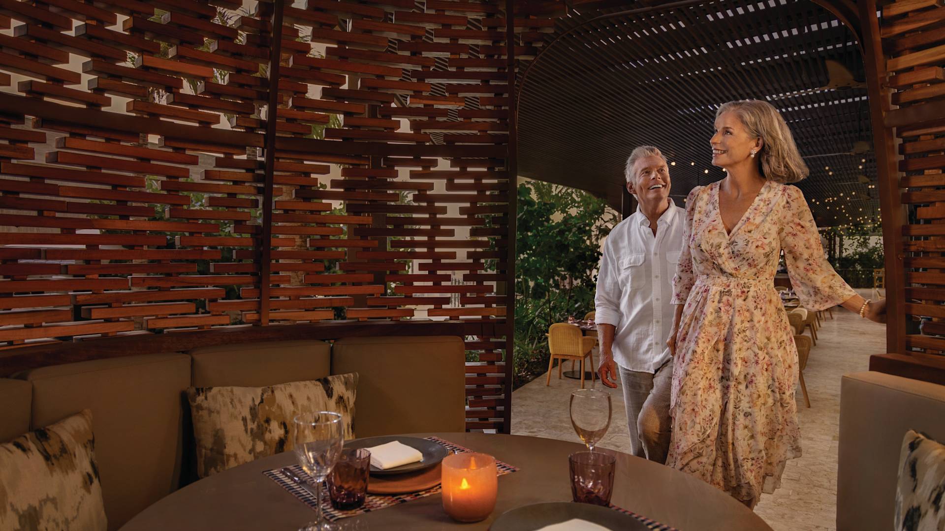 Two people approach a dinner table