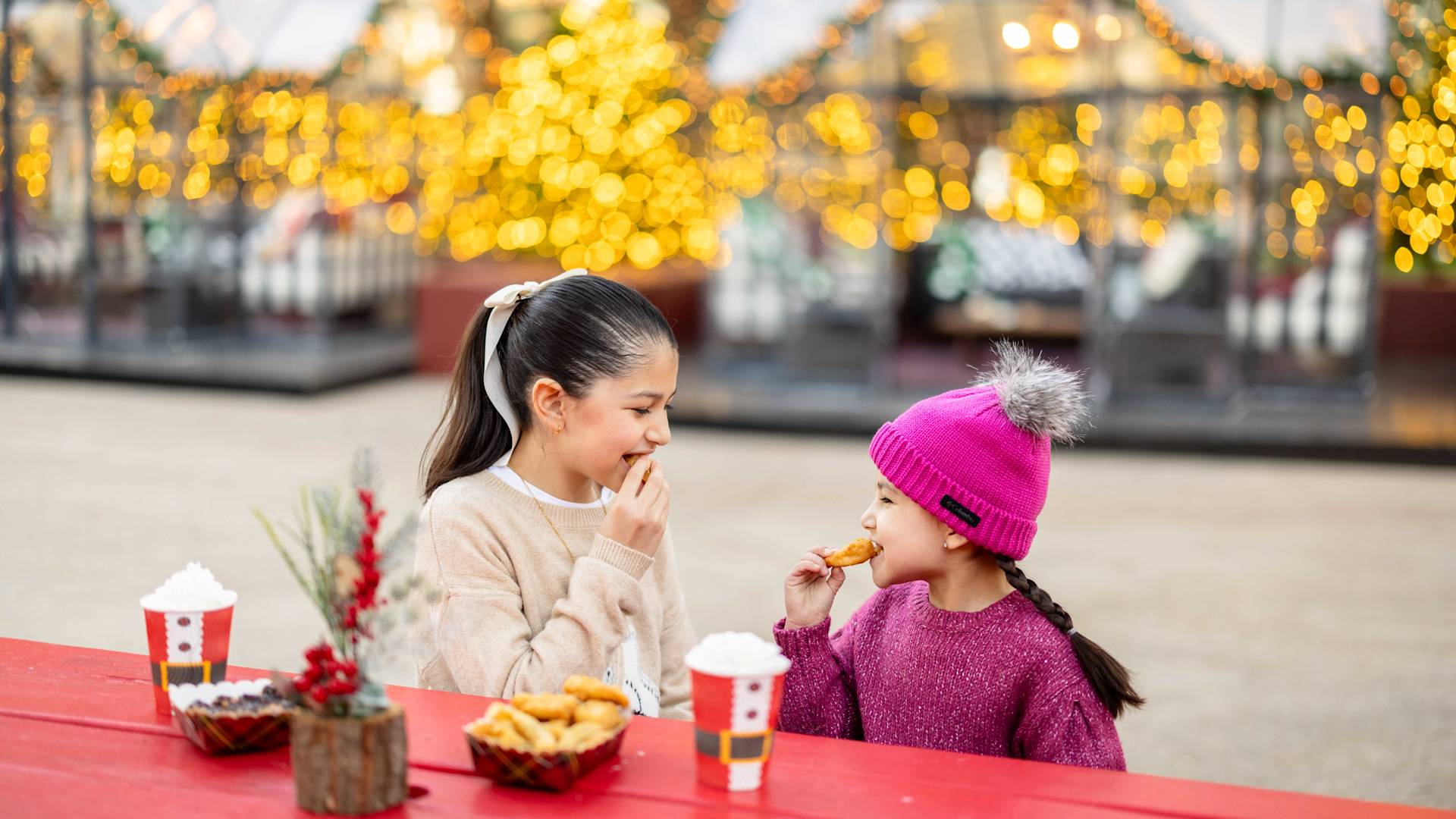 Girls Enjoying Cookies and Hot Chocolate Outdoors at Christmas Time-transition