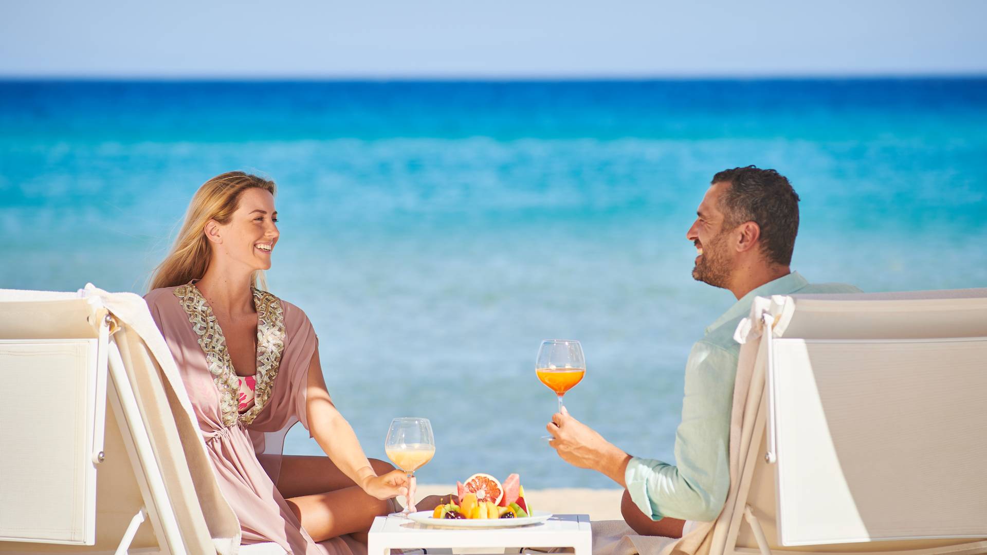 Una coppia che sorseggia un drink sulla spiaggia