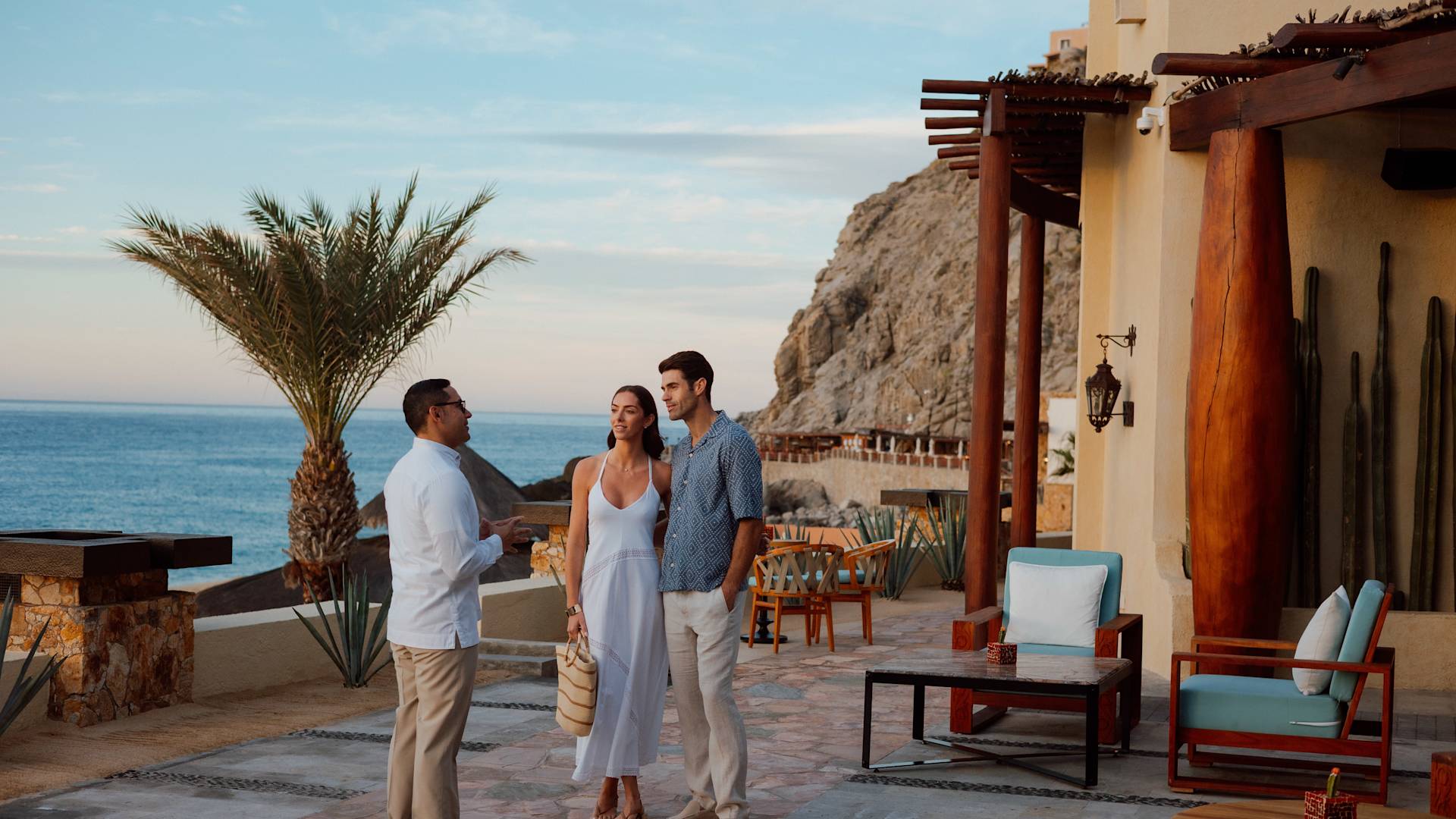 casal conversando com o concierge do lado de fora do lobby do resort