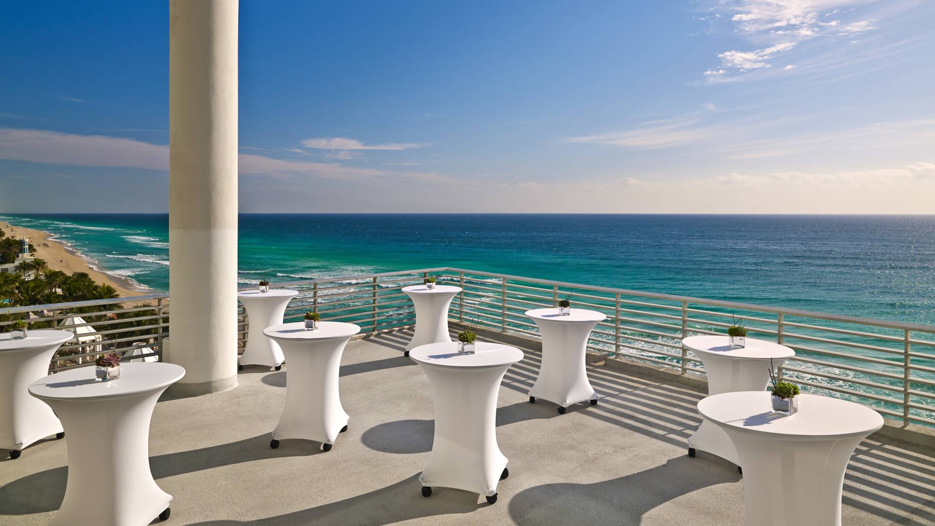 Ruang pertemuan luar ruangan dengan meja dan pemandangan laut-transisi