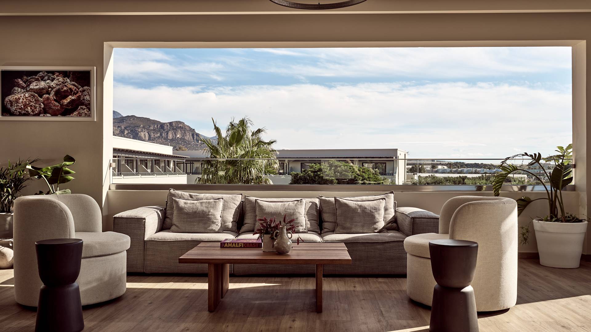 Coin détente du hall avec un grand canapé confortable, des chaises et une vue sur l'eau - transition