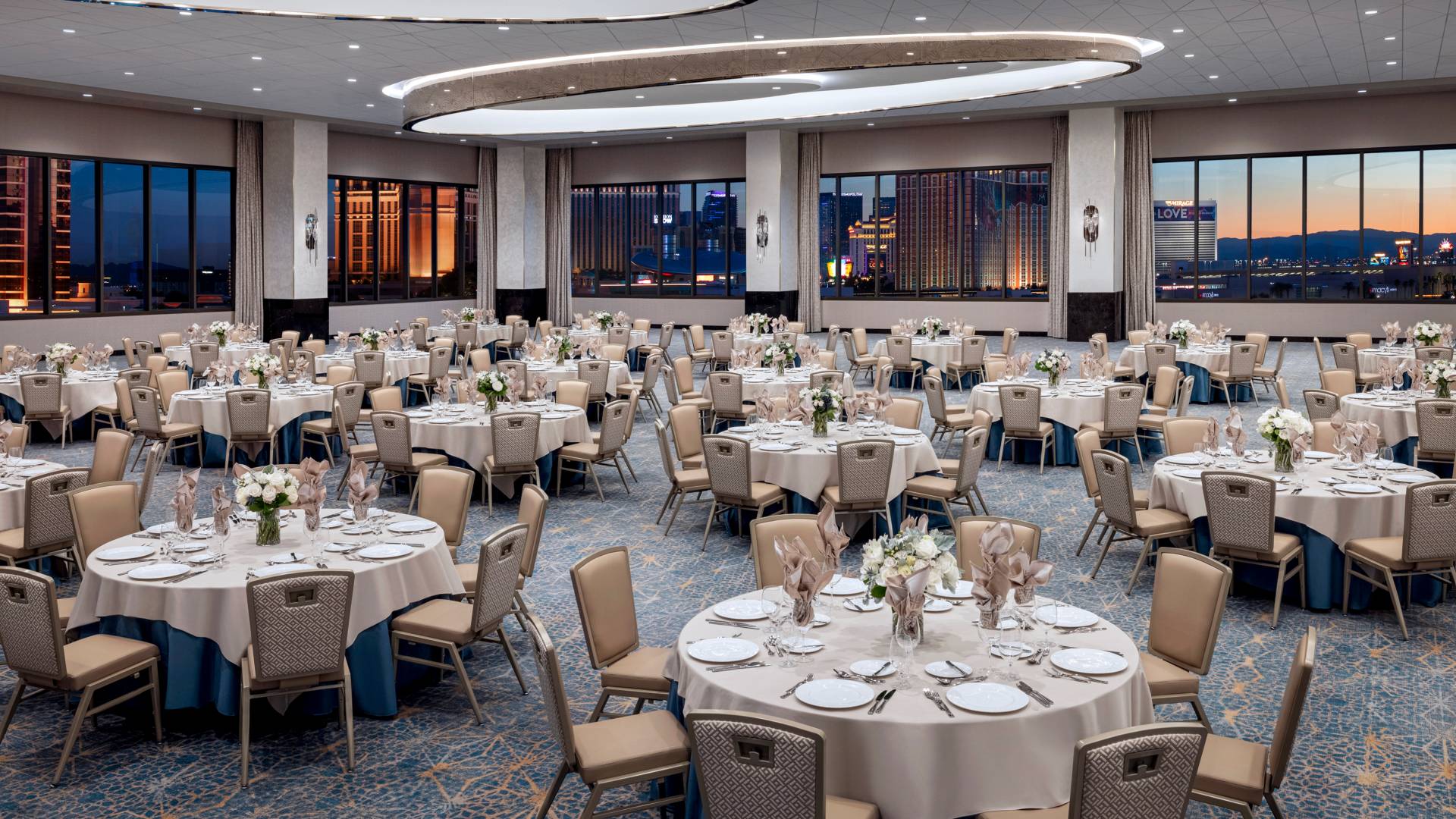 salle de réception avec tables rondes et chaises aménagées pour un banquet-transition