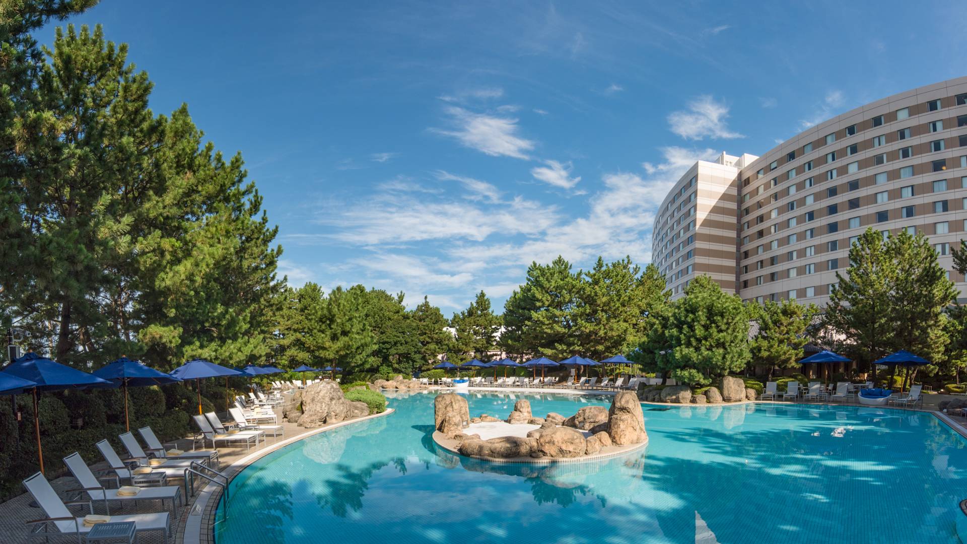 Daytime View of Blue Sun Umbrellas and Relaxation Loungers by Pool-transition