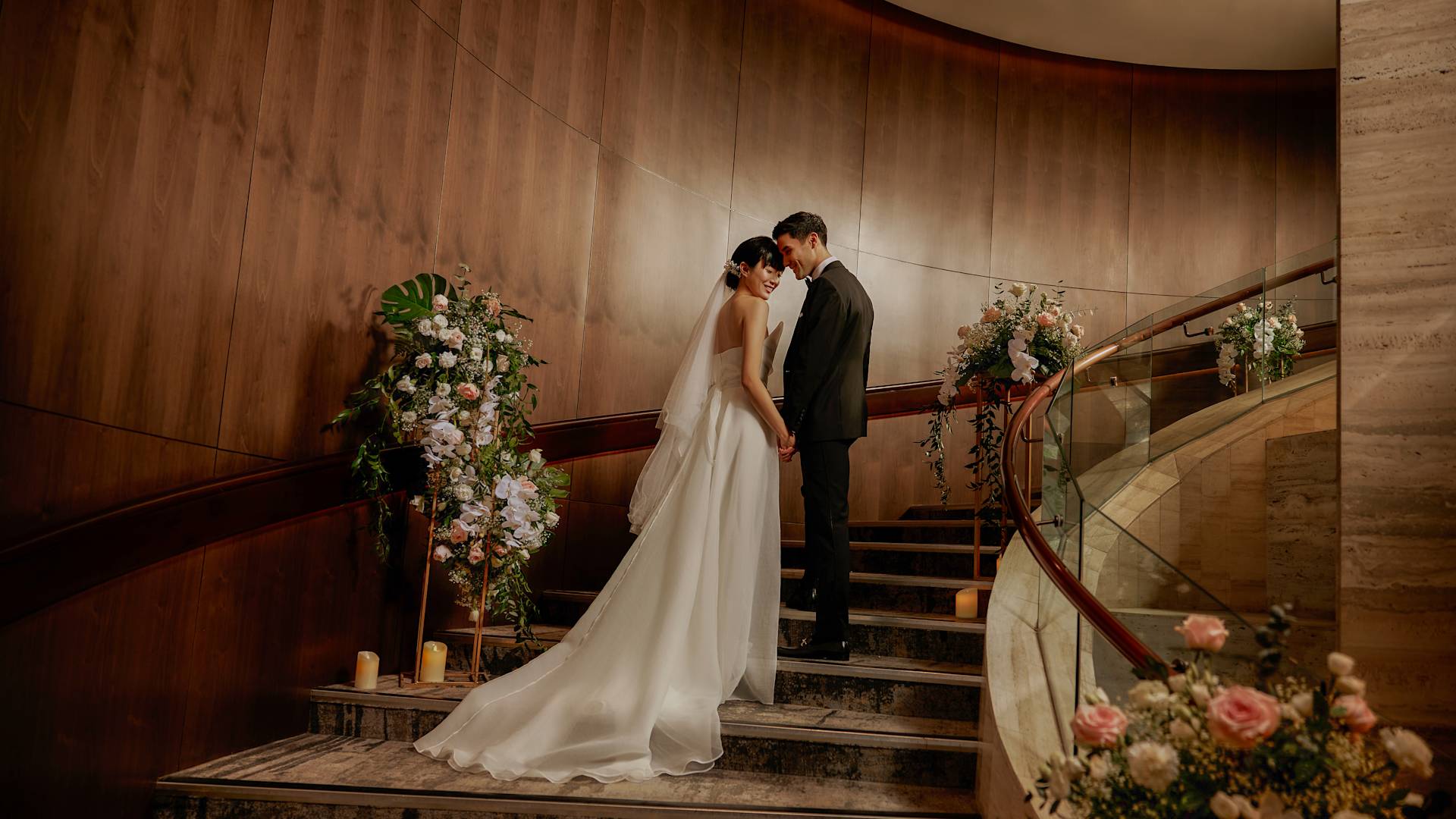 Wedding Couple Standing at Ballroom Stairs with Flowers-transition