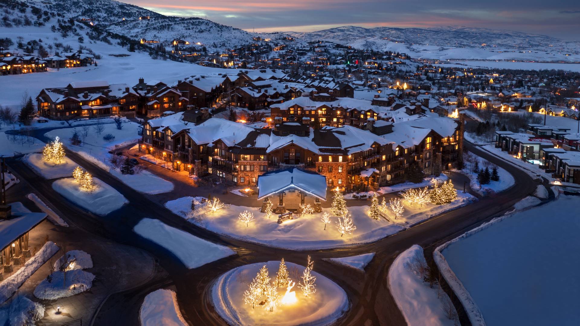 Fachada del hotel por la noche y vista de las montañas cubiertas de transición de nieve