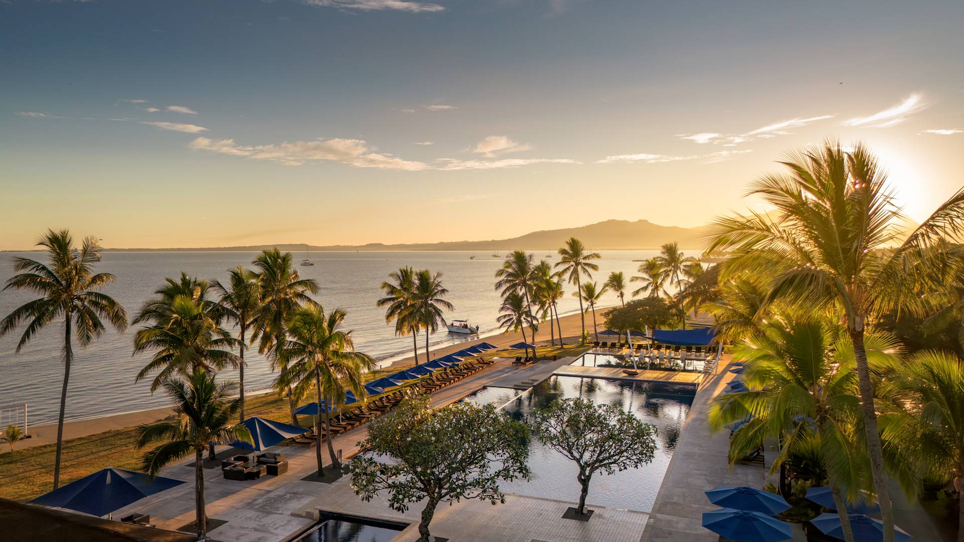 Aerial view of the main pool with the ocean behind it.-transition