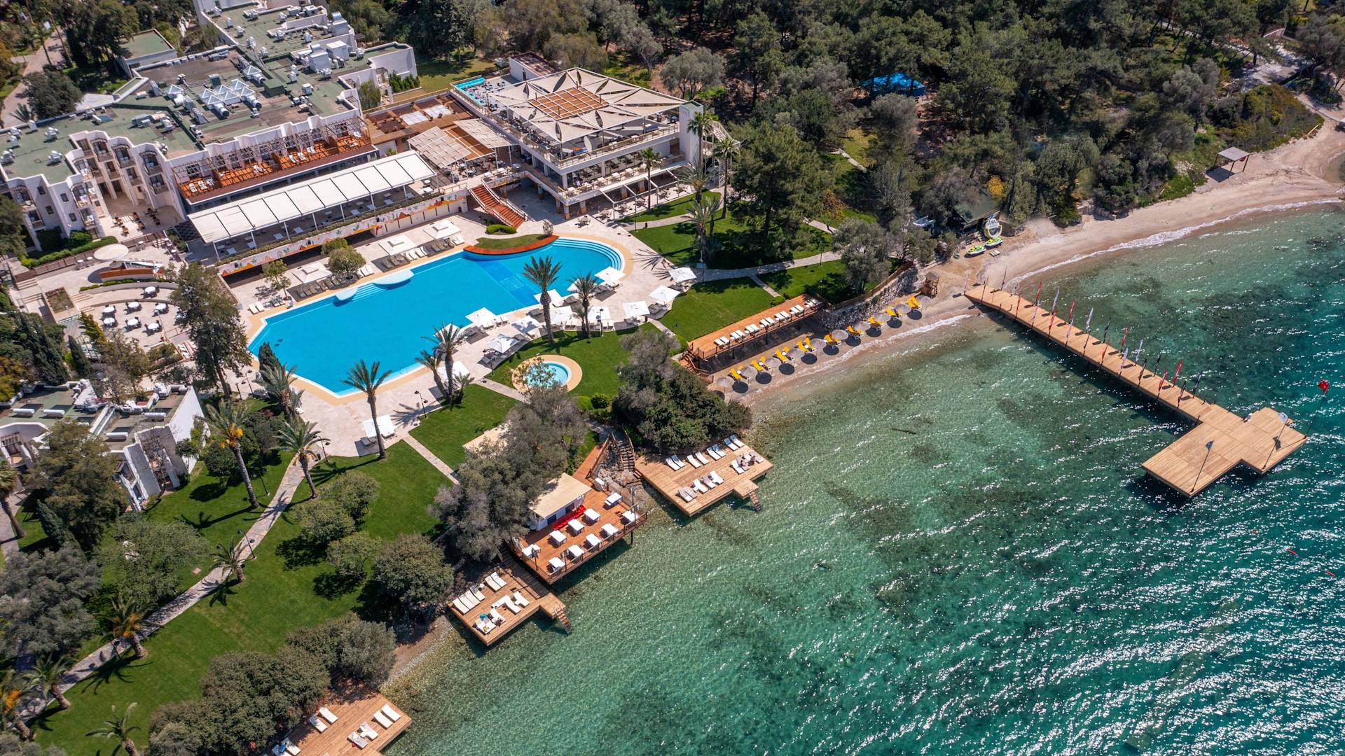 Vue aérienne de l'extérieur d'un hôtel en bord de mer avec une grande piscine