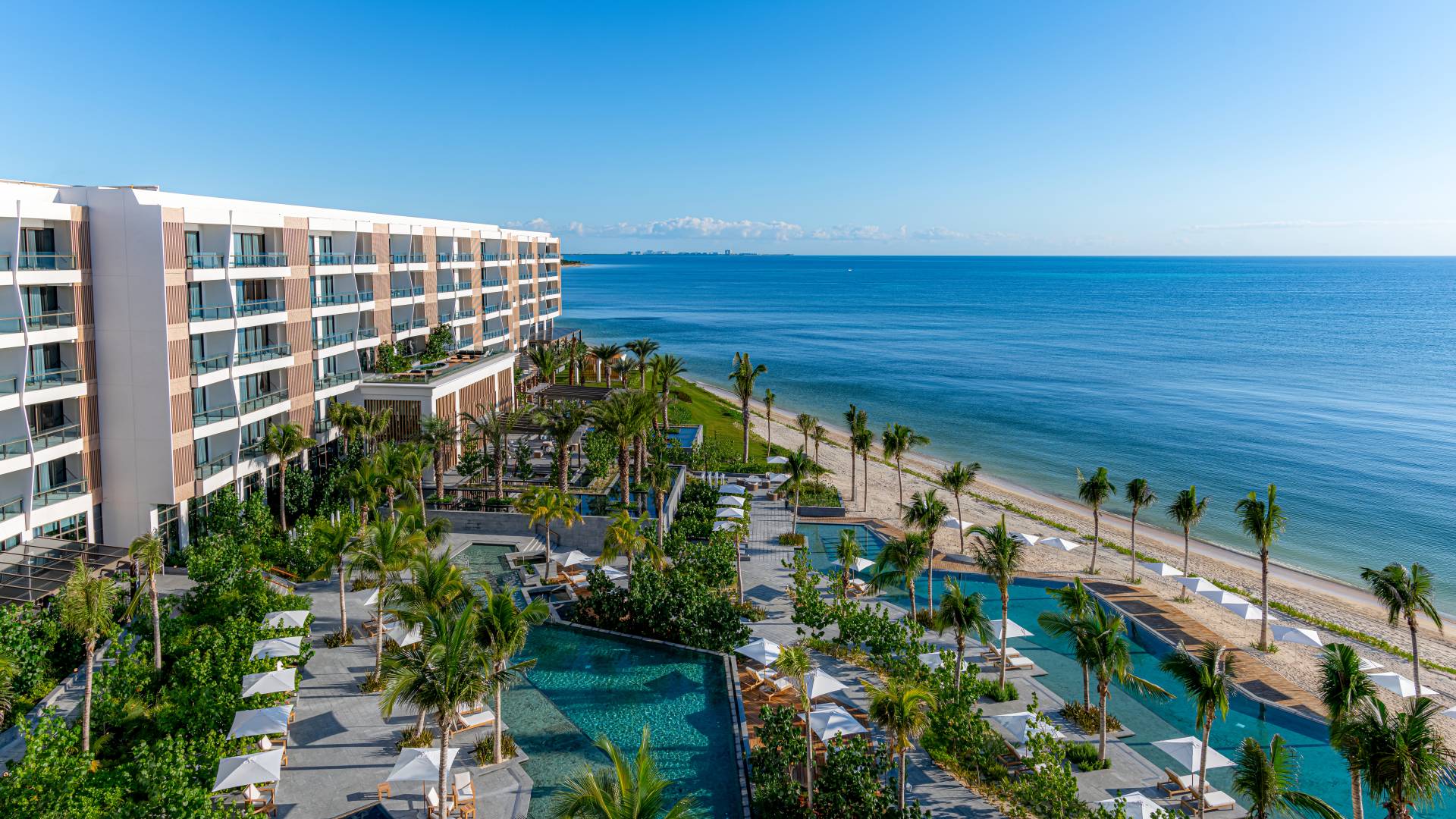 Fachada del hotel, piscinas al aire libre y playa cercana