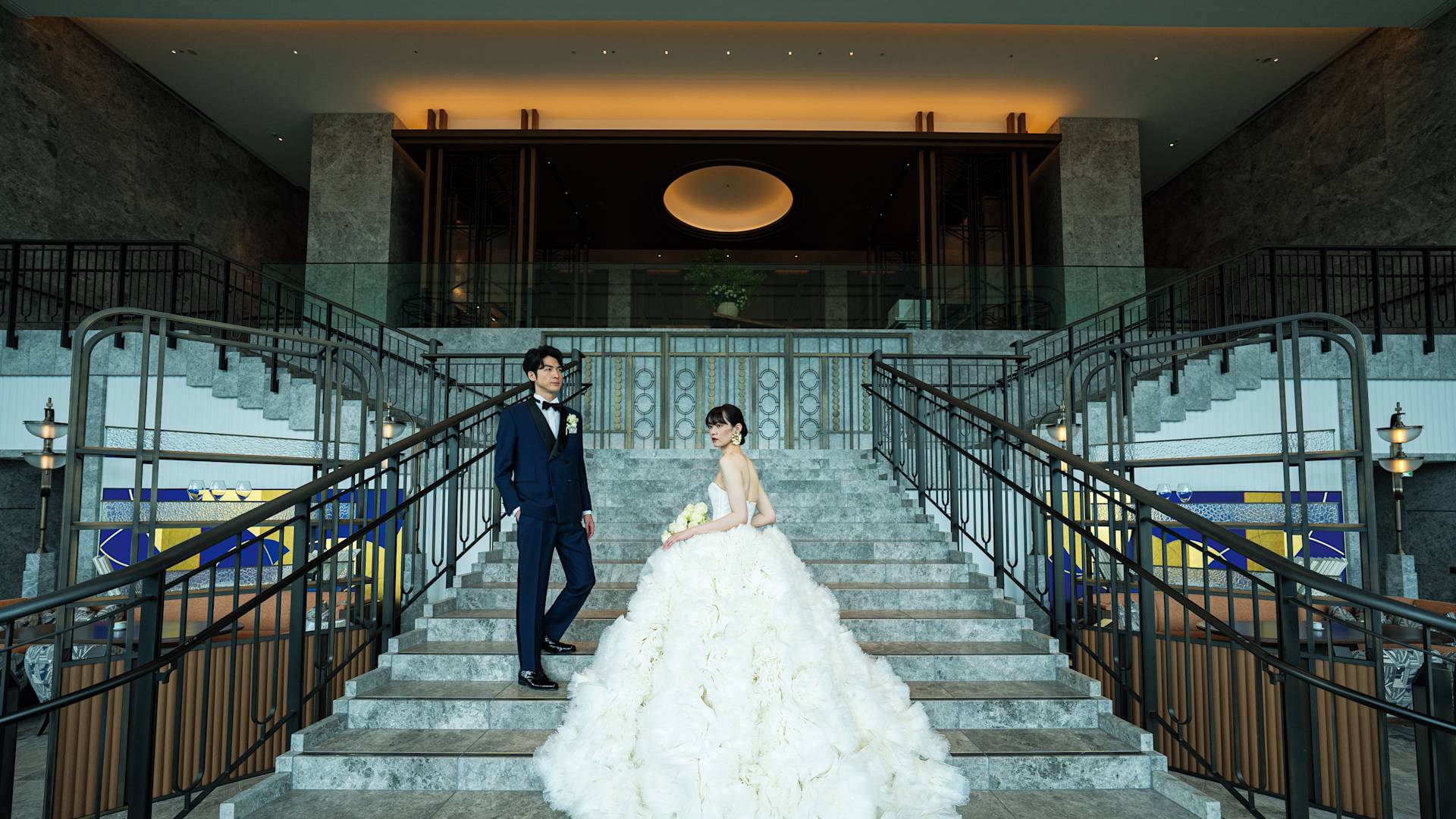 Braut und Bräutigam gehen eine große Treppe hinauf.-Übergang