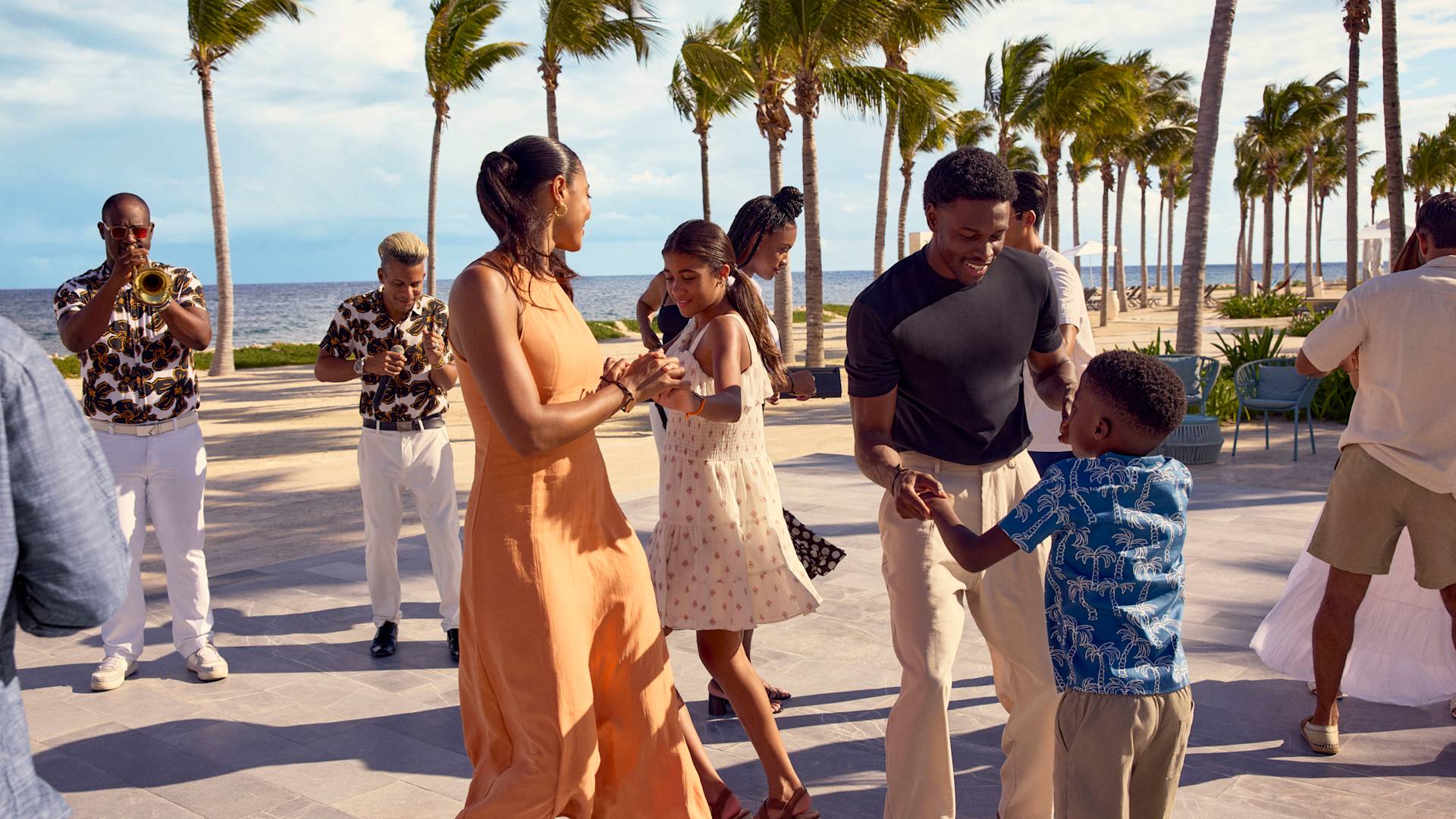 Mother, teenage daughter, father and son are having fun at a dance class on the beach