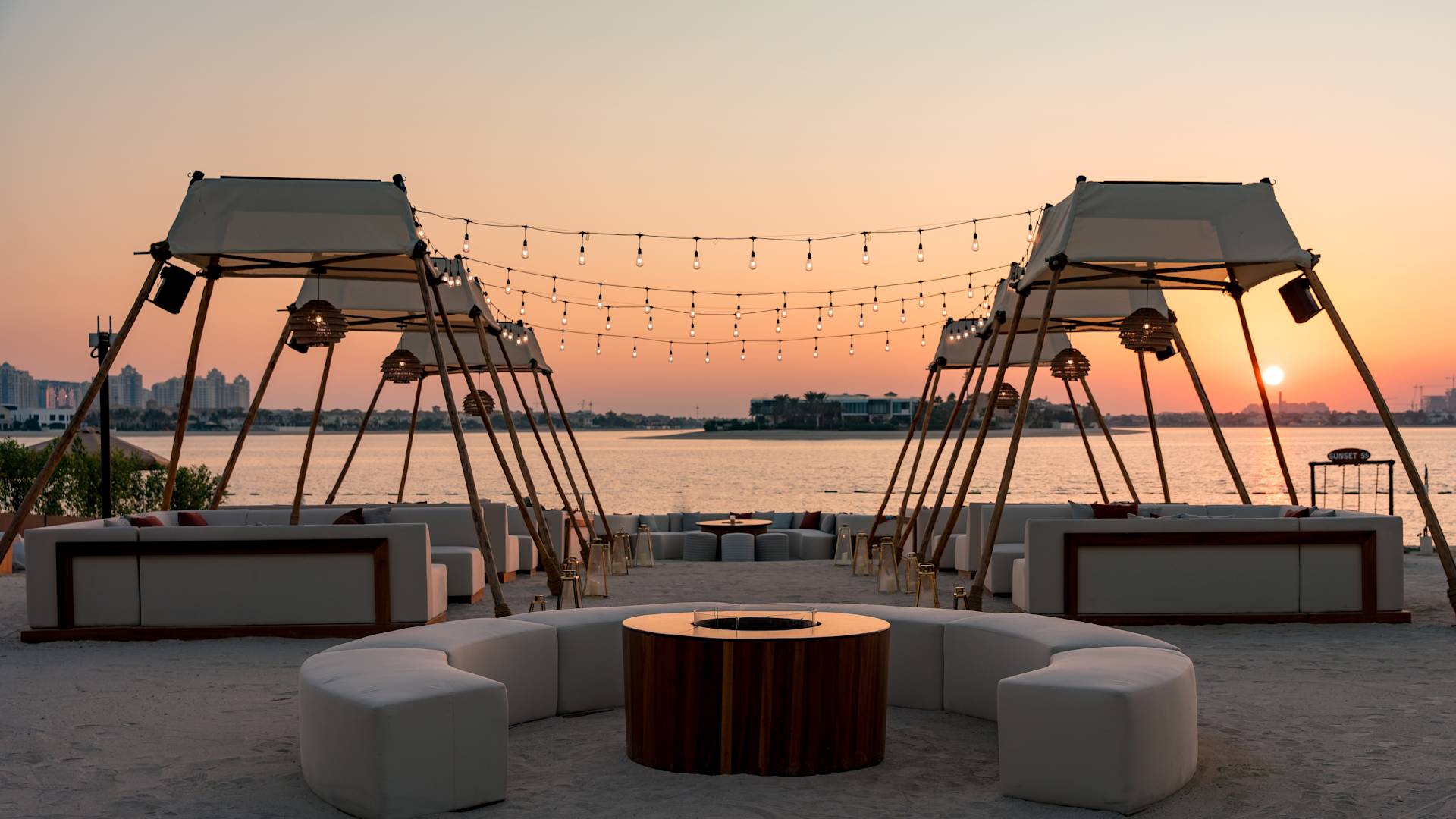 夕暮れ時のファイヤーピットを備えたビーチカバナ55つとラウンジエリア