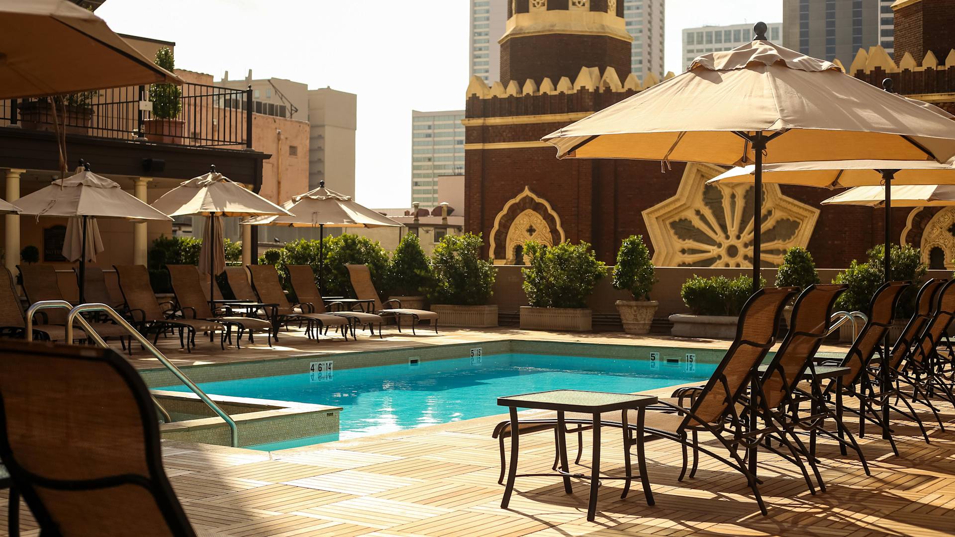 户外游泳池，配有遮阳伞下的躺椅