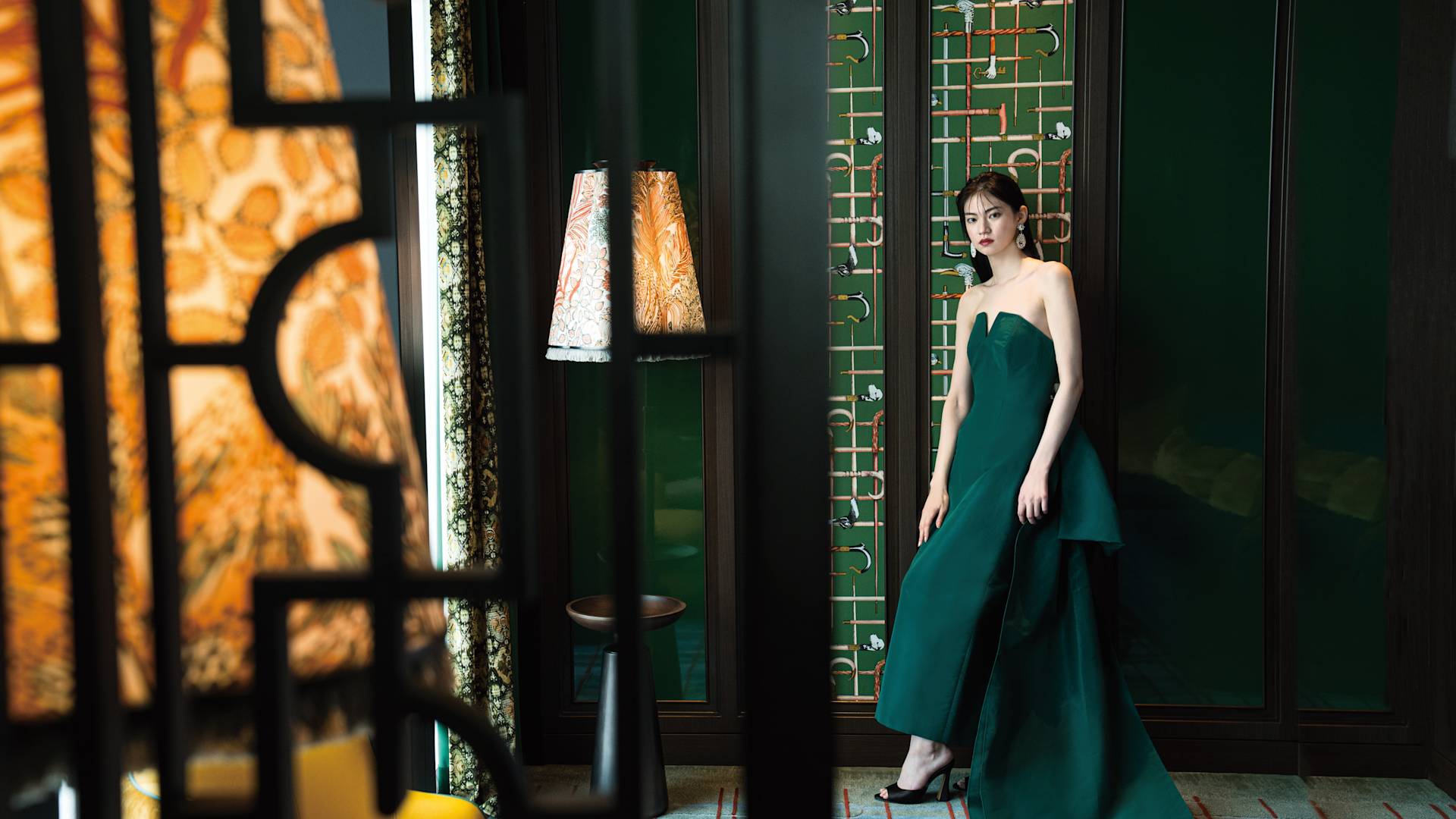 Brautjungfrau steht vor einer Wand.