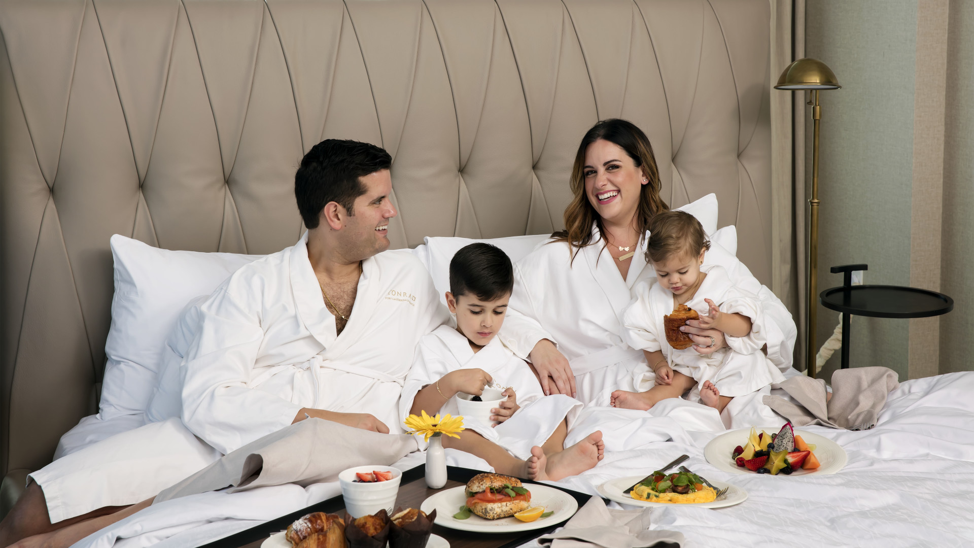 Family in Suite on Bed eating breakfast