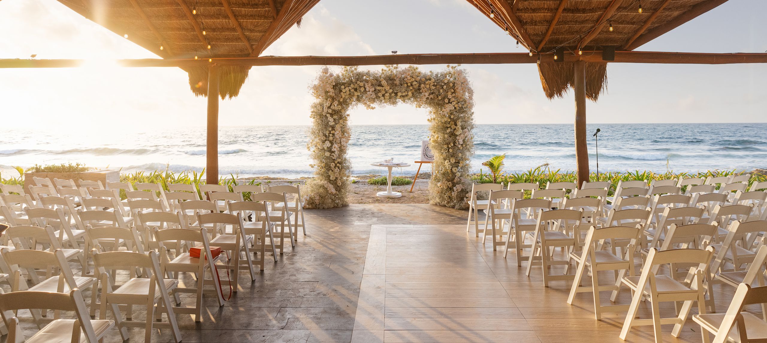 Wedding venue set up with chairs for guests and arch on oceanfront